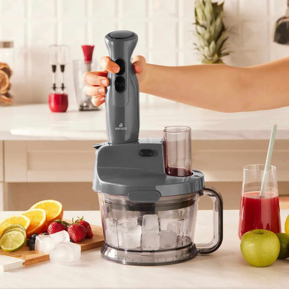 Gri el blender buz küpleri üzerinde, mutfak robotunda. Yanında meyve ve meyve suyu.