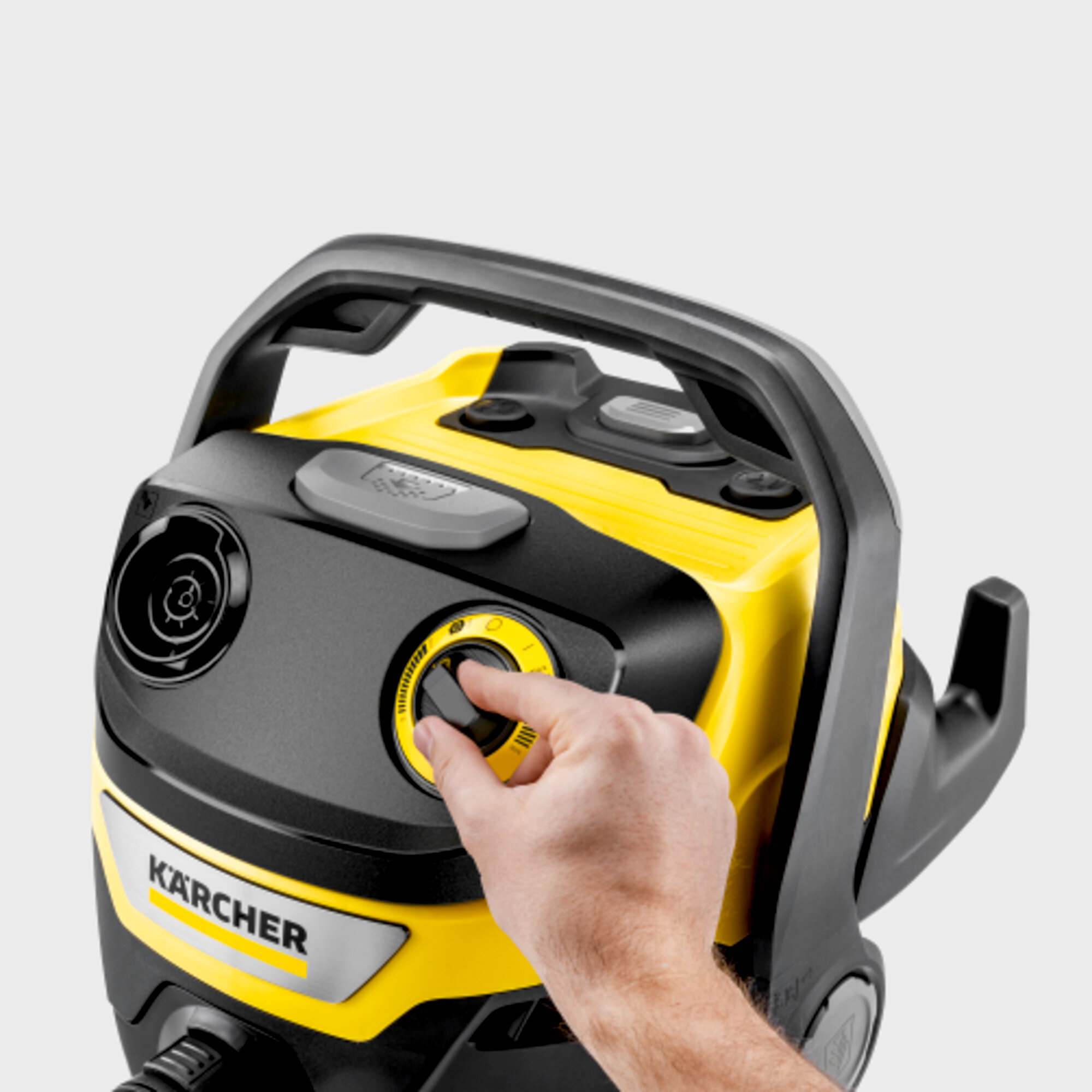 Una mano gira un quadrante giallo su un pulitore Karcher.