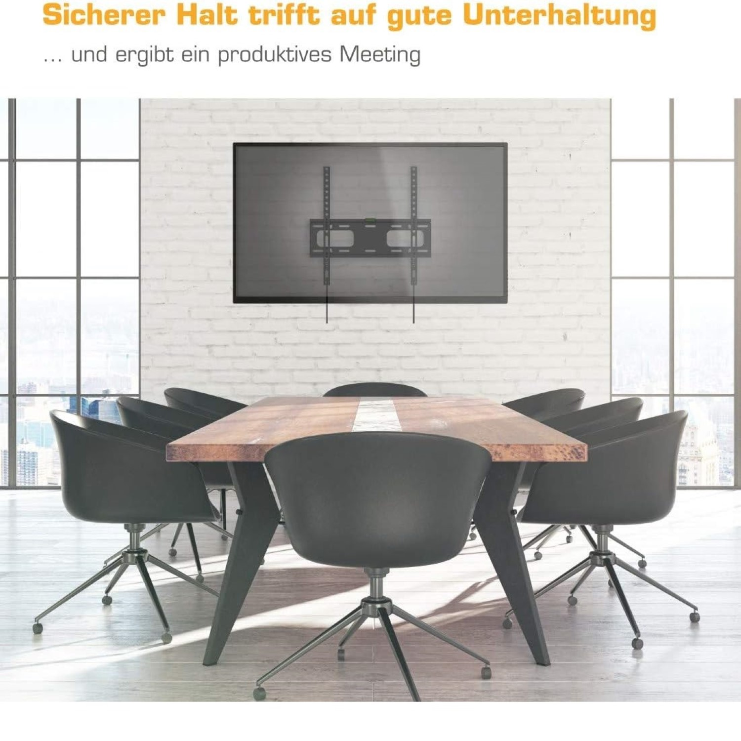 Ein Konferenztisch mit schwarzen Stühlen und einem Wand-TV in einem hellen Raum.