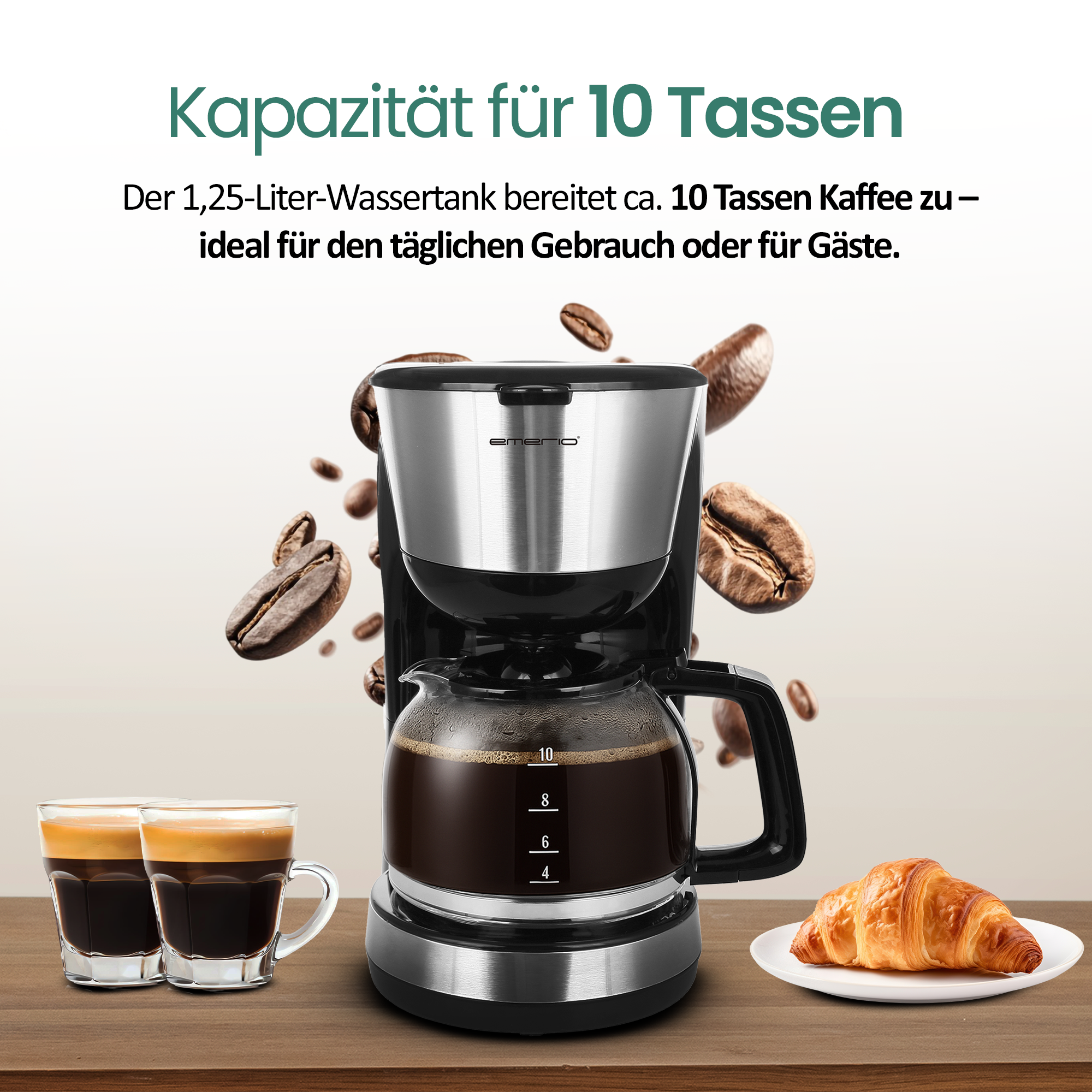 Kaffeemaschine mit Glaskanne, zwei Espressotassen und einem Croissant.