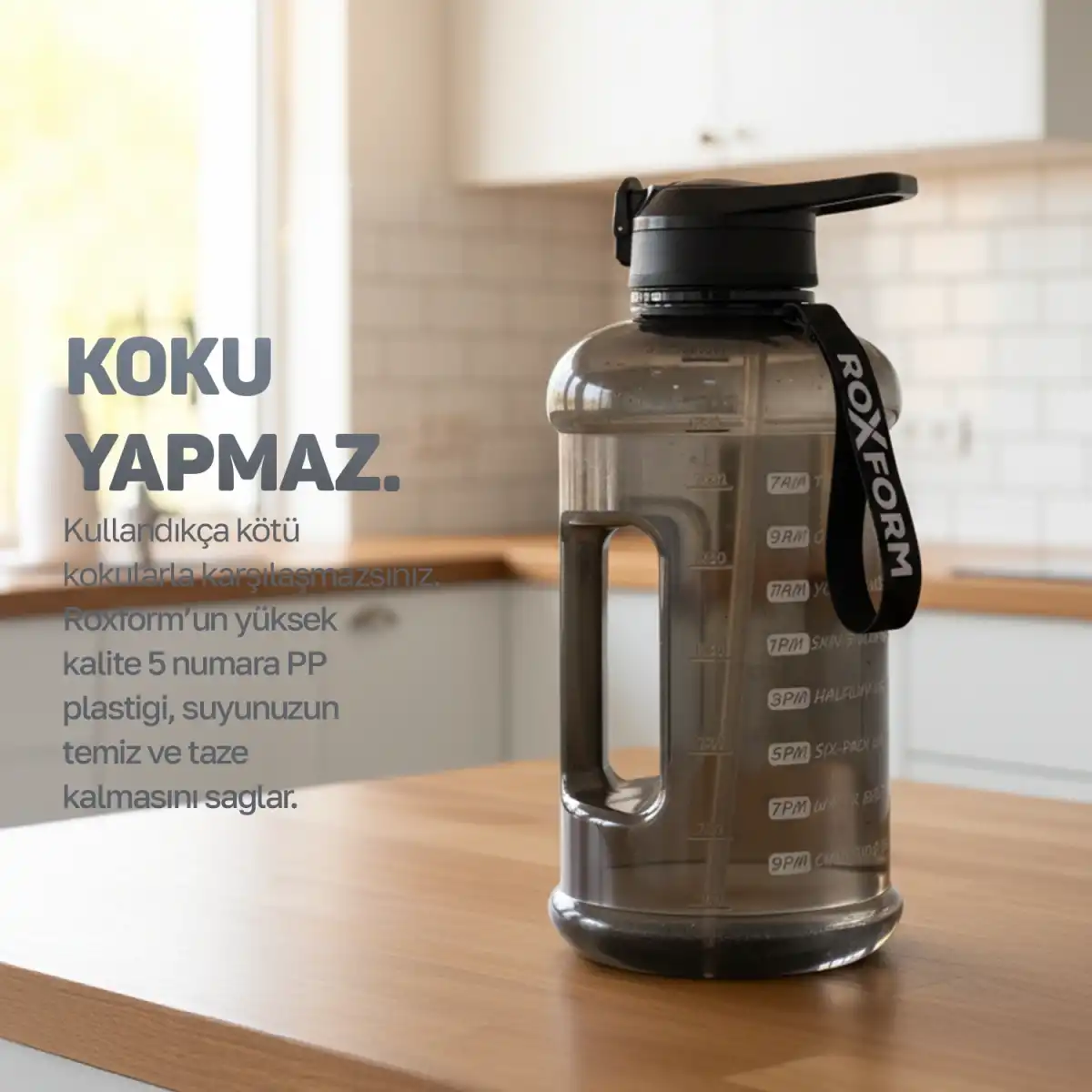 Ahşap mutfak masasında zaman işaretleri olan gri su şişesi.