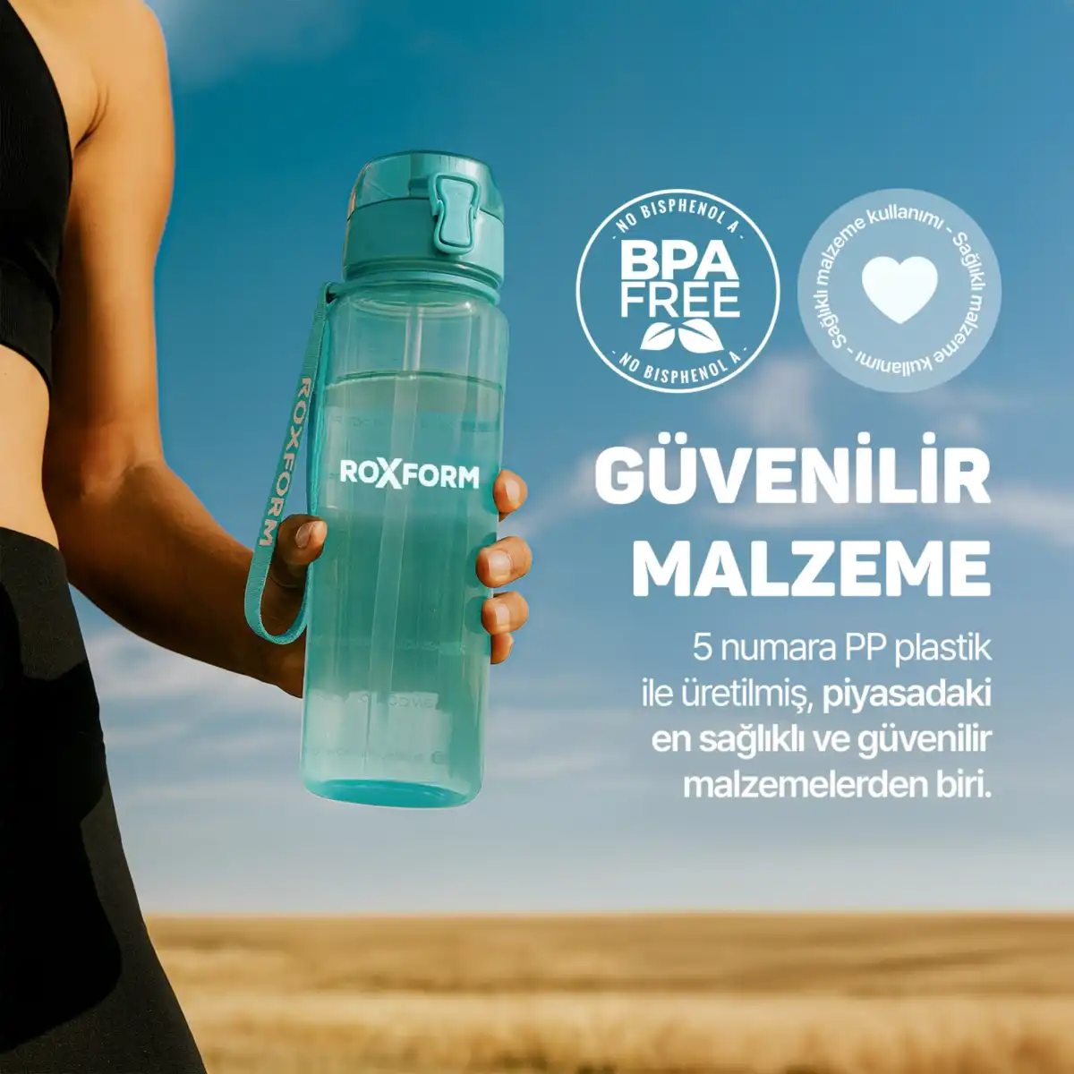 Bir el, mavi gökyüzü ve tarla önünde mavi bir ROXFORM su şişesi tutuyor.