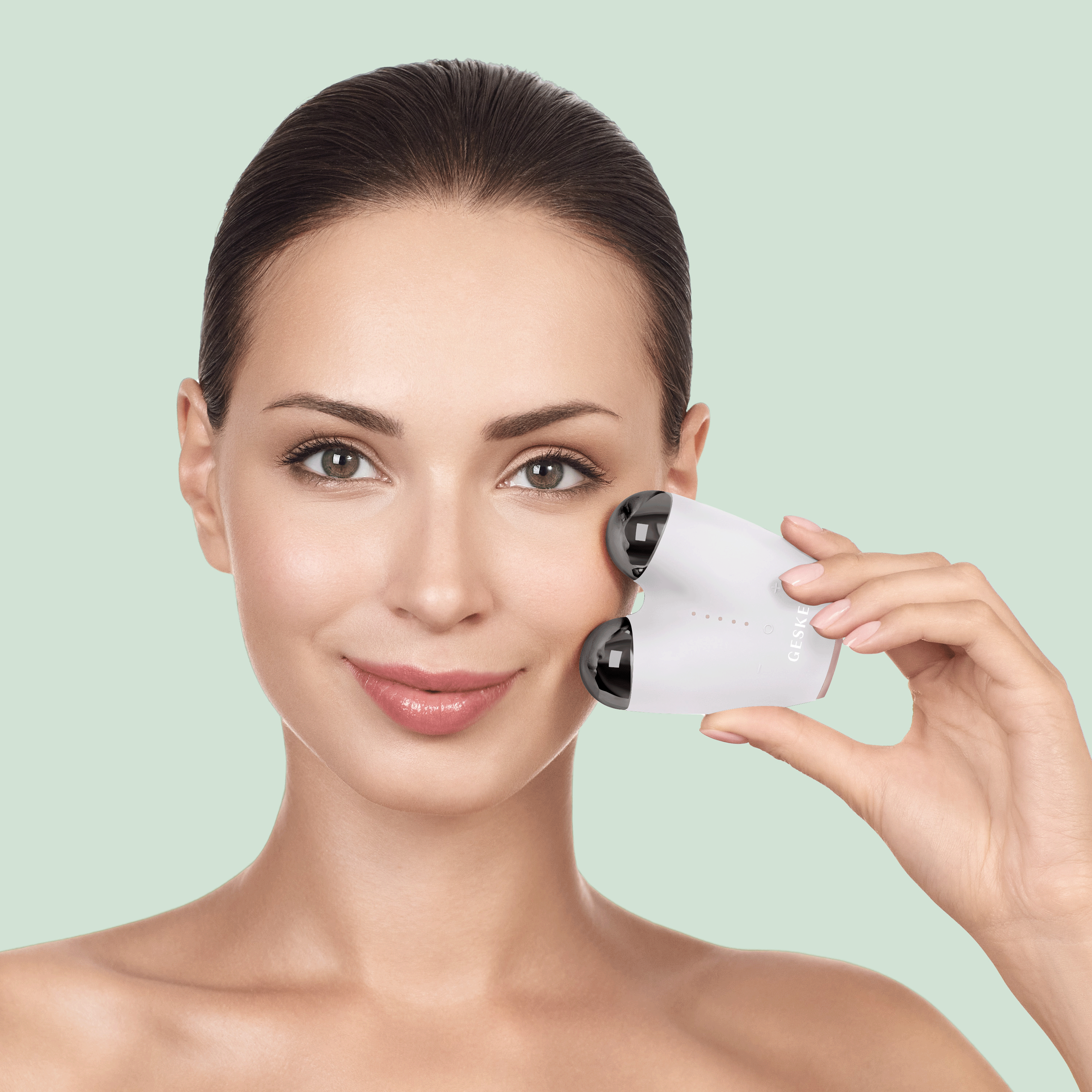 Una donna usa un dispositivo cosmetico per il viso su sfondo verde chiaro.