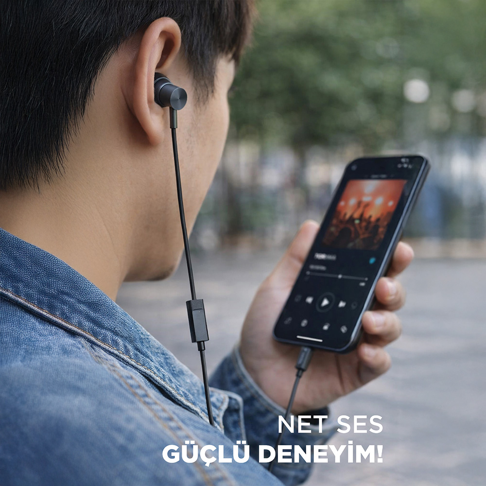 Kot ceketli kişi kulaklıkla telefonda müzik dinliyor.