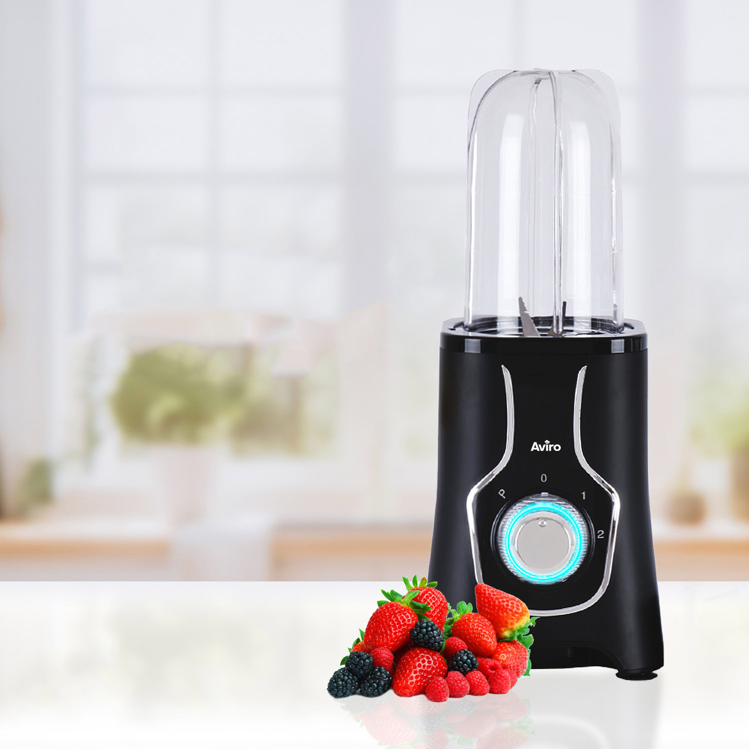 Black blender with mixed berries: strawberries, blackberries, raspberries on white surface.
