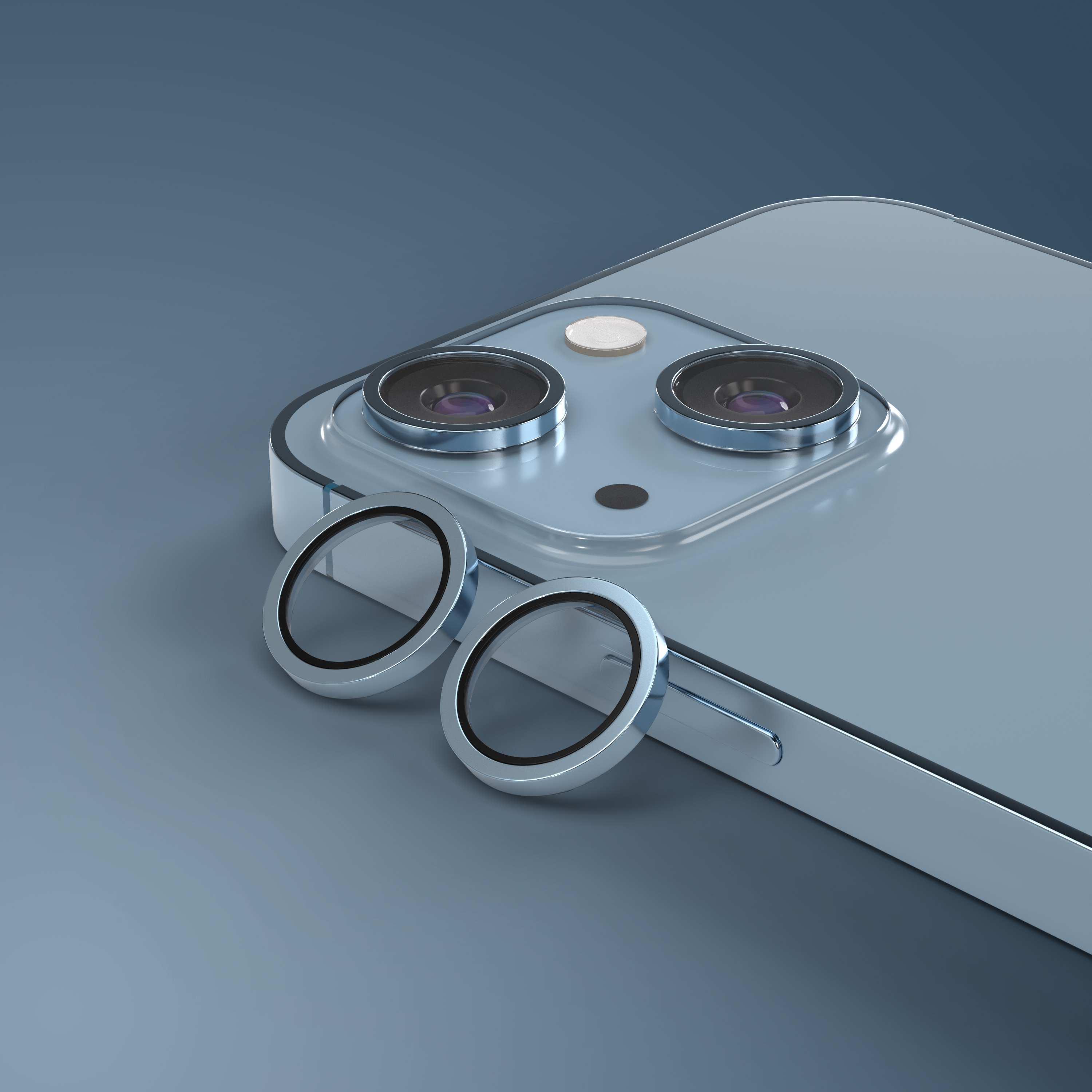 Due anelli protettivi giacciono accanto al modulo fotocamera di uno smartphone blu.