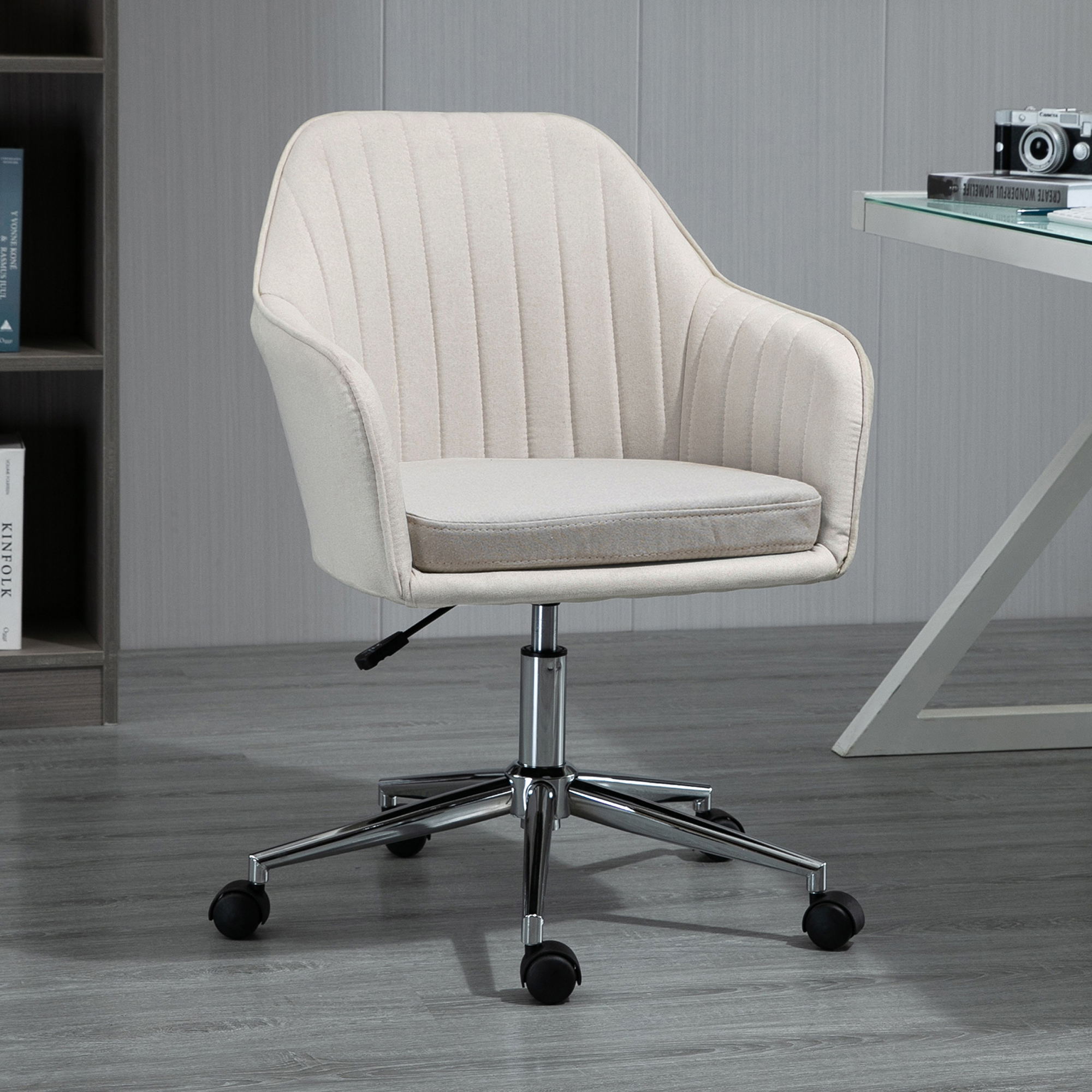 Una silla de oficina tapizada beige con ruedas está sobre un suelo de madera.