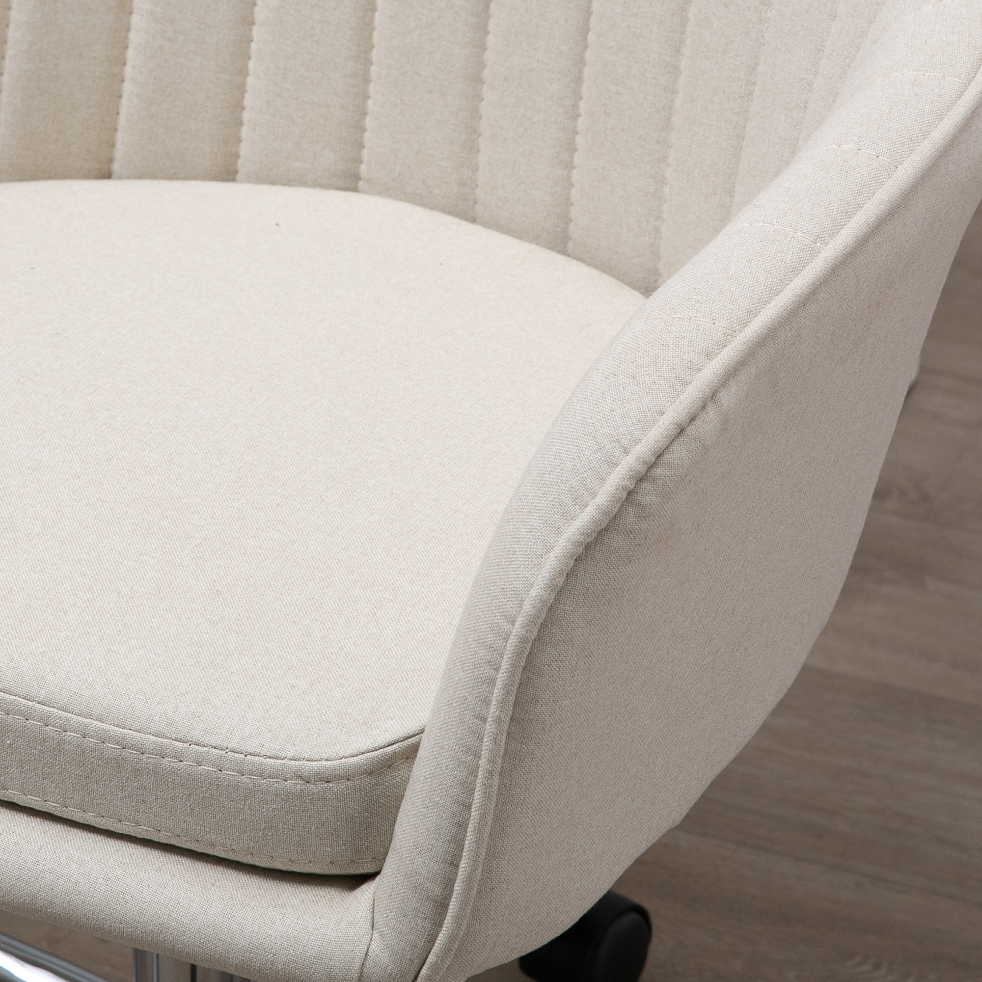 Una silla de tela beige con costuras verticales y cojín de asiento.