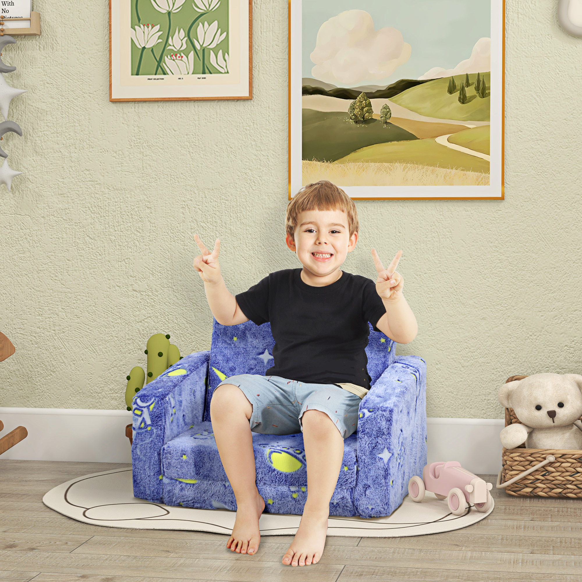 Un niño se sienta en un sillón azul con estrellas, haciendo el signo de la paz.