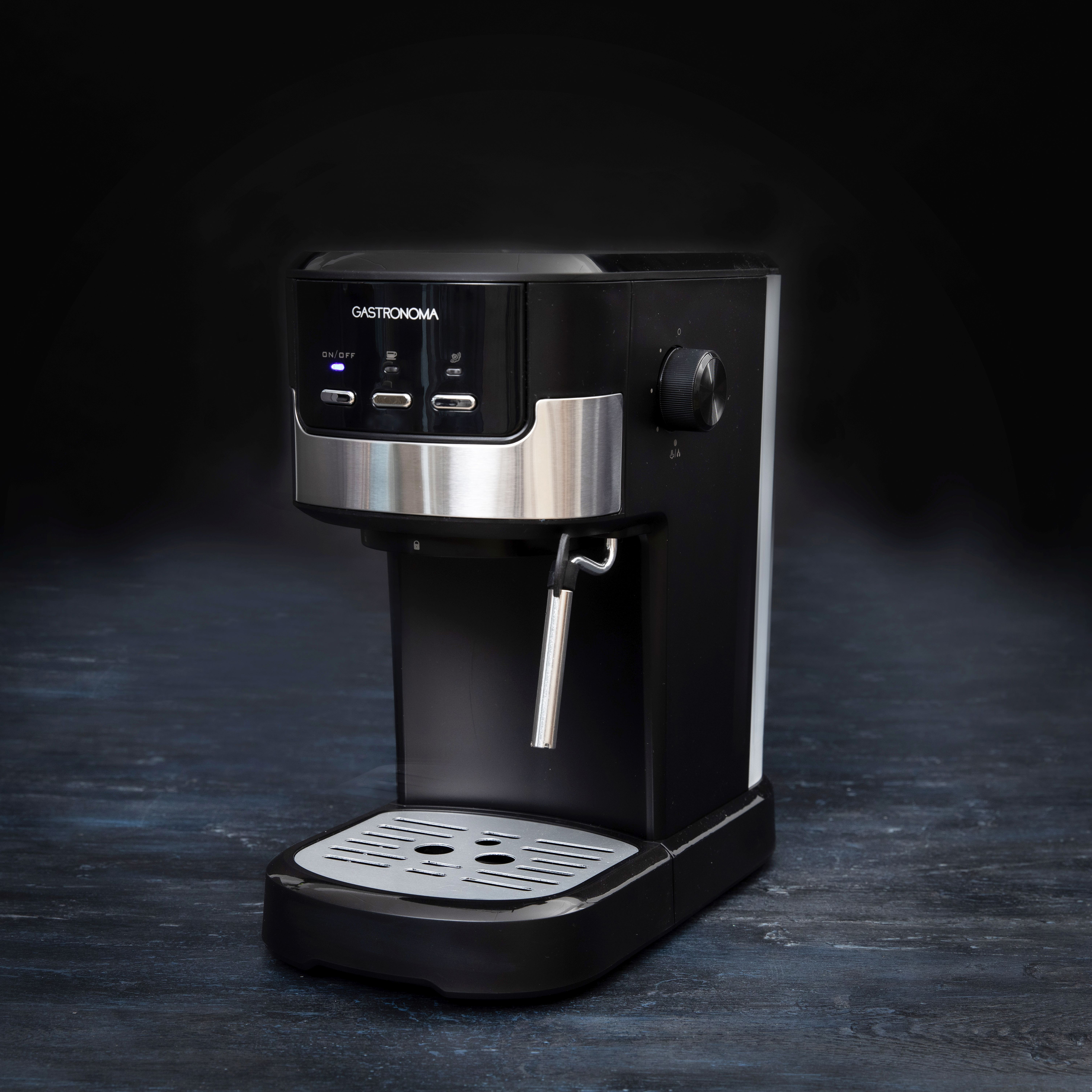 Czarny ekspres do kawy z srebrnymi akcentami na ciemnym tle.