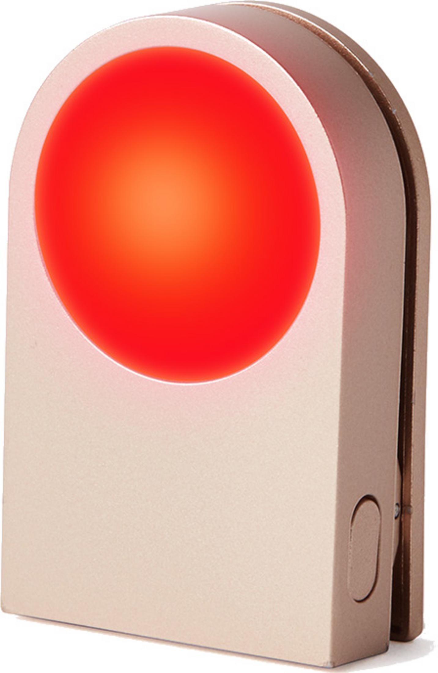 Una luz roja circular brillando en un dispositivo beige.