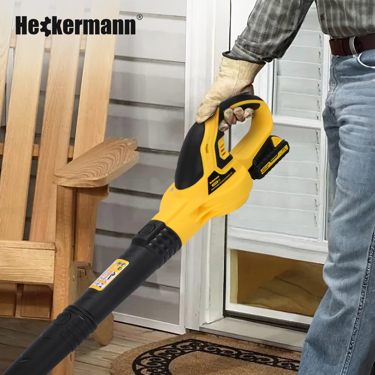 Osoba trzyma żółto-czarną dmuchawę do liści w pobliżu drewnianego ganku.