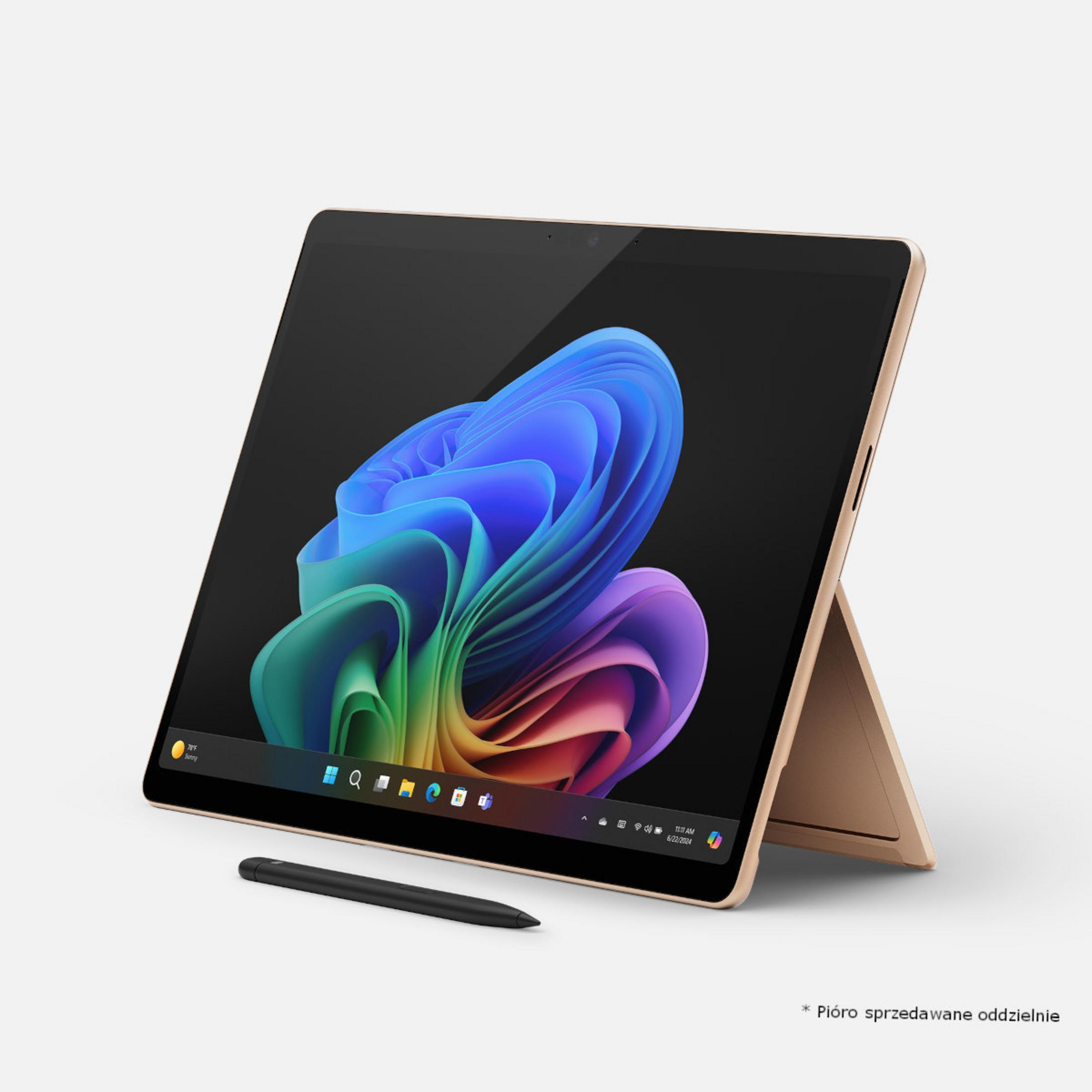 Złoty laptop z kolorową tapetą i rysikiem.