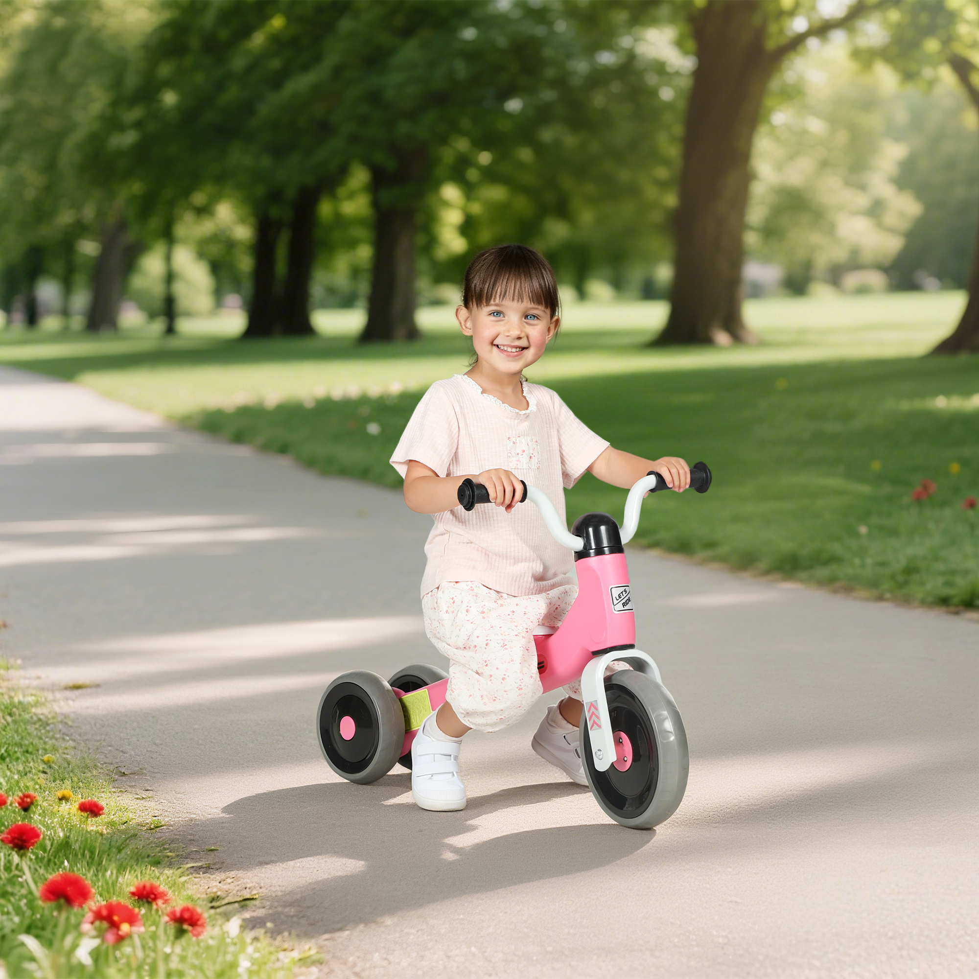 Una niña pequeña monta un triciclo rosa en un camino del parque.