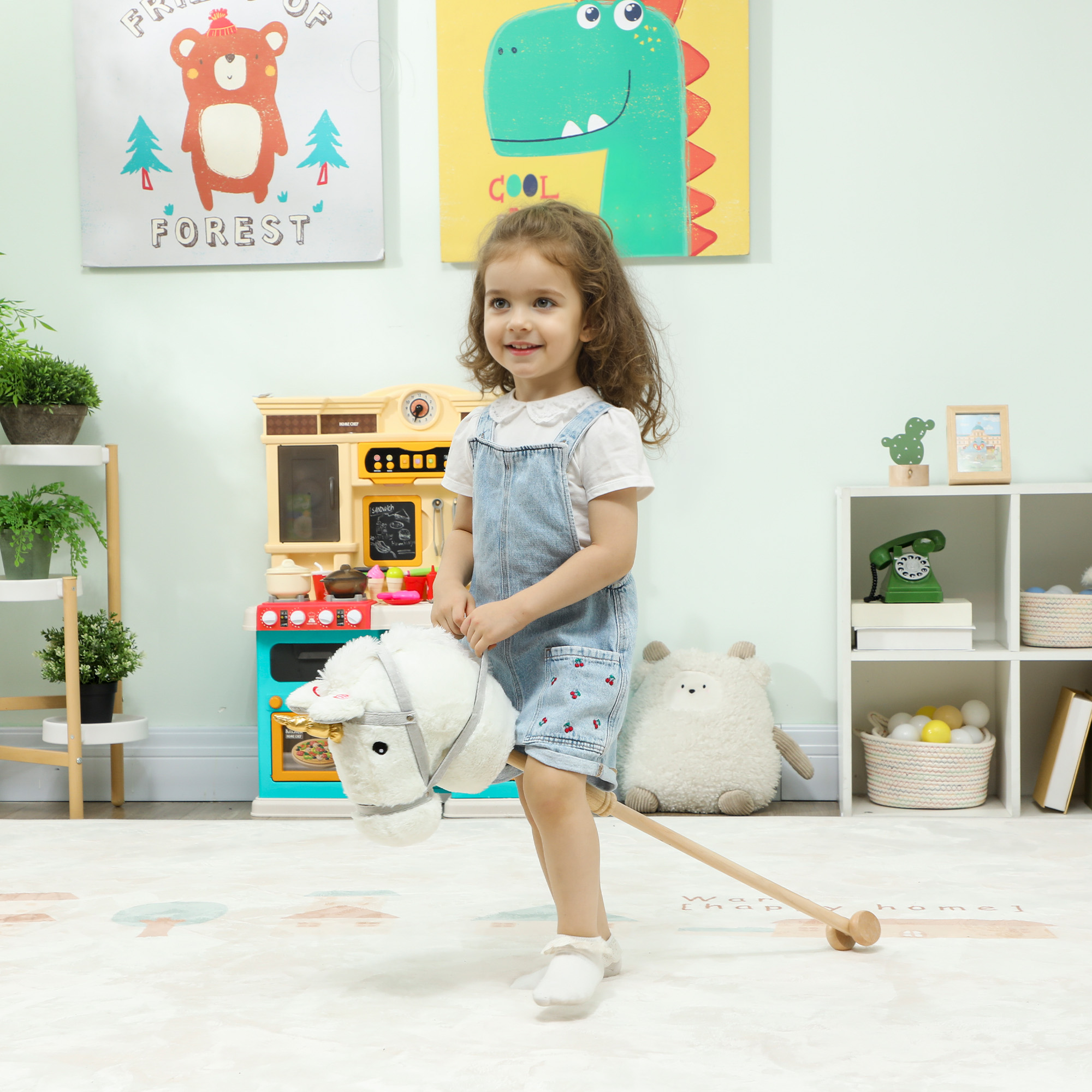 Una niña pequeña monta un caballo de juguete blanco en una cocina de juguete con cuadros coloridos.