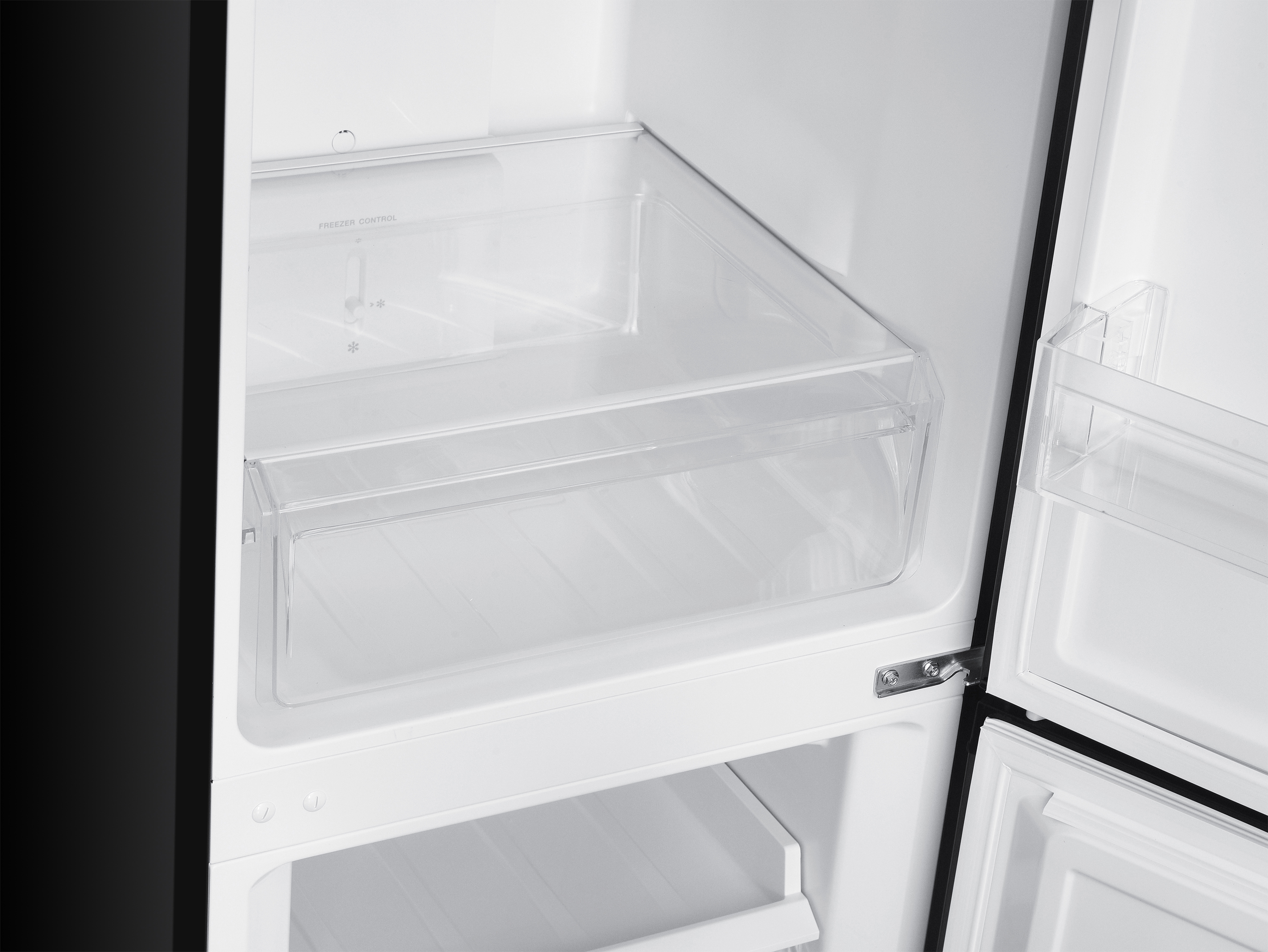 Ein leerer Kühlschrank mit transparenten Schubladen und Gefrierfachkontrolle.