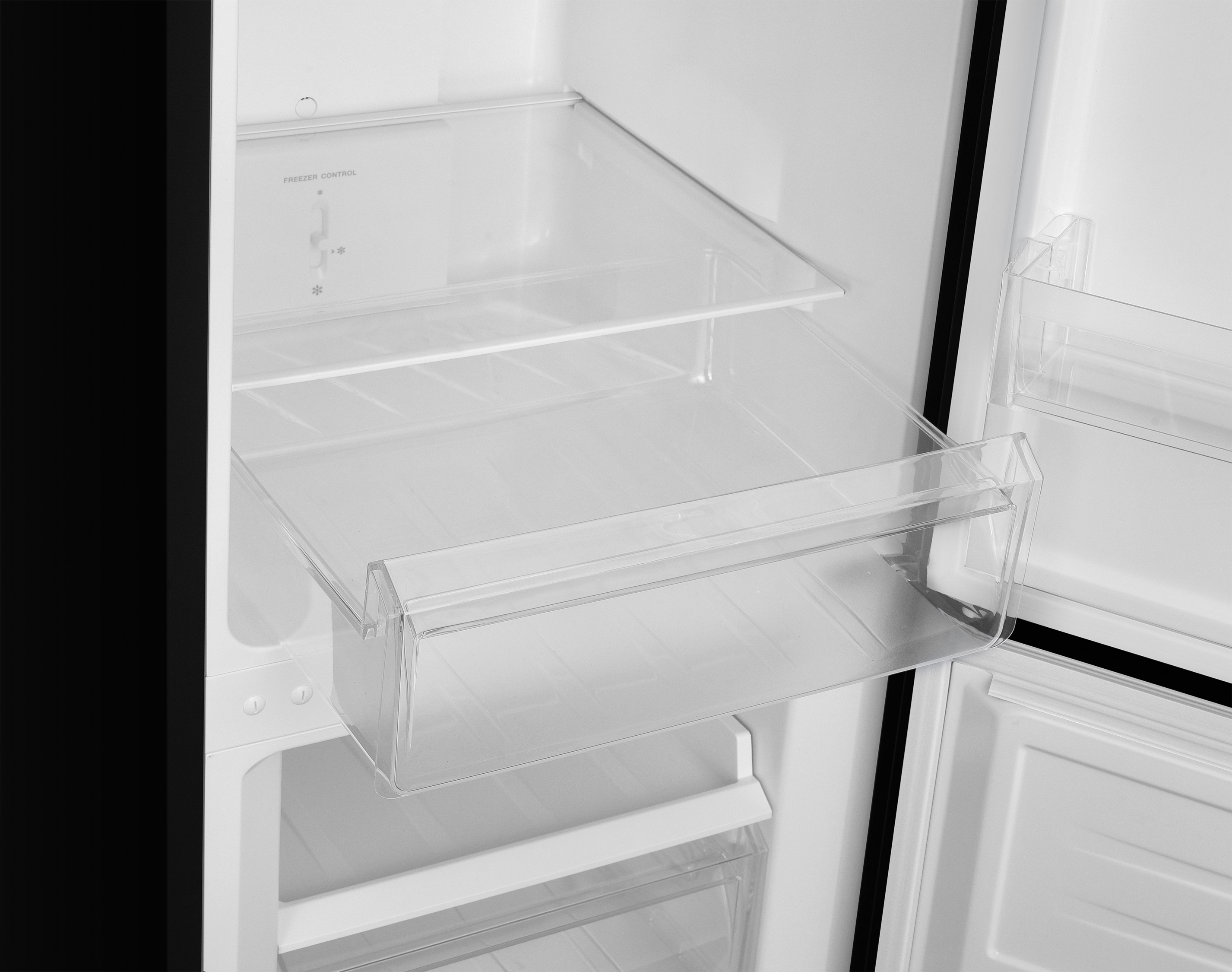 Ein leerer Kühlschrank mit einem ausziehbaren Fach und Gefrierregler.