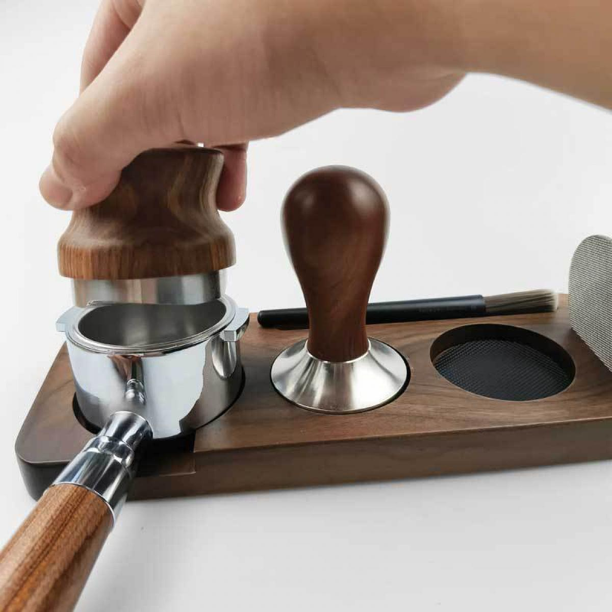 Holz-Tamper und Siebträger auf Holzbrett mit Bürste und Sieb.