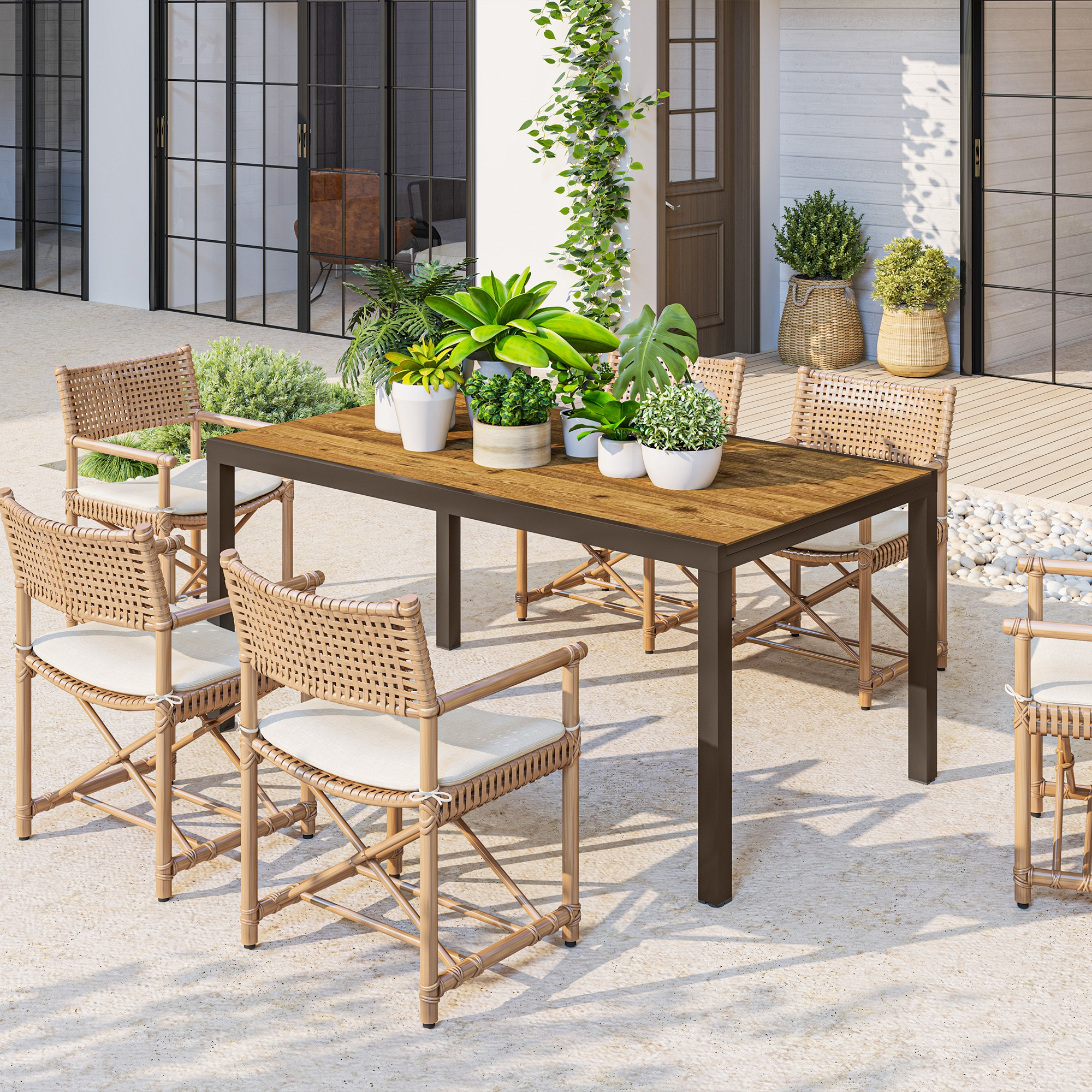 Una mesa de comedor de madera con seis sillas de ratán con cojines blancos en un patio.