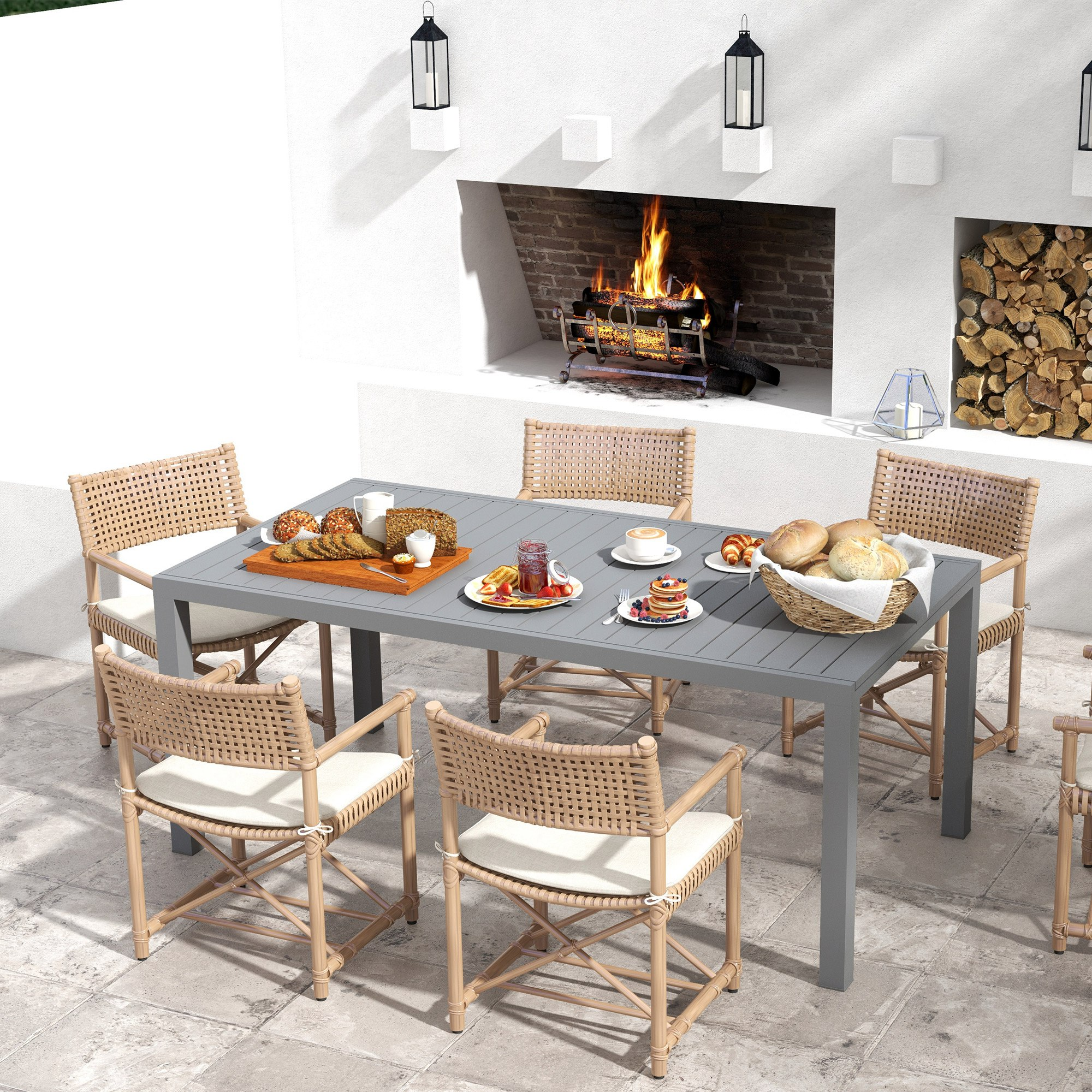 Mesa de patio con comida frente a una chimenea con fuego.