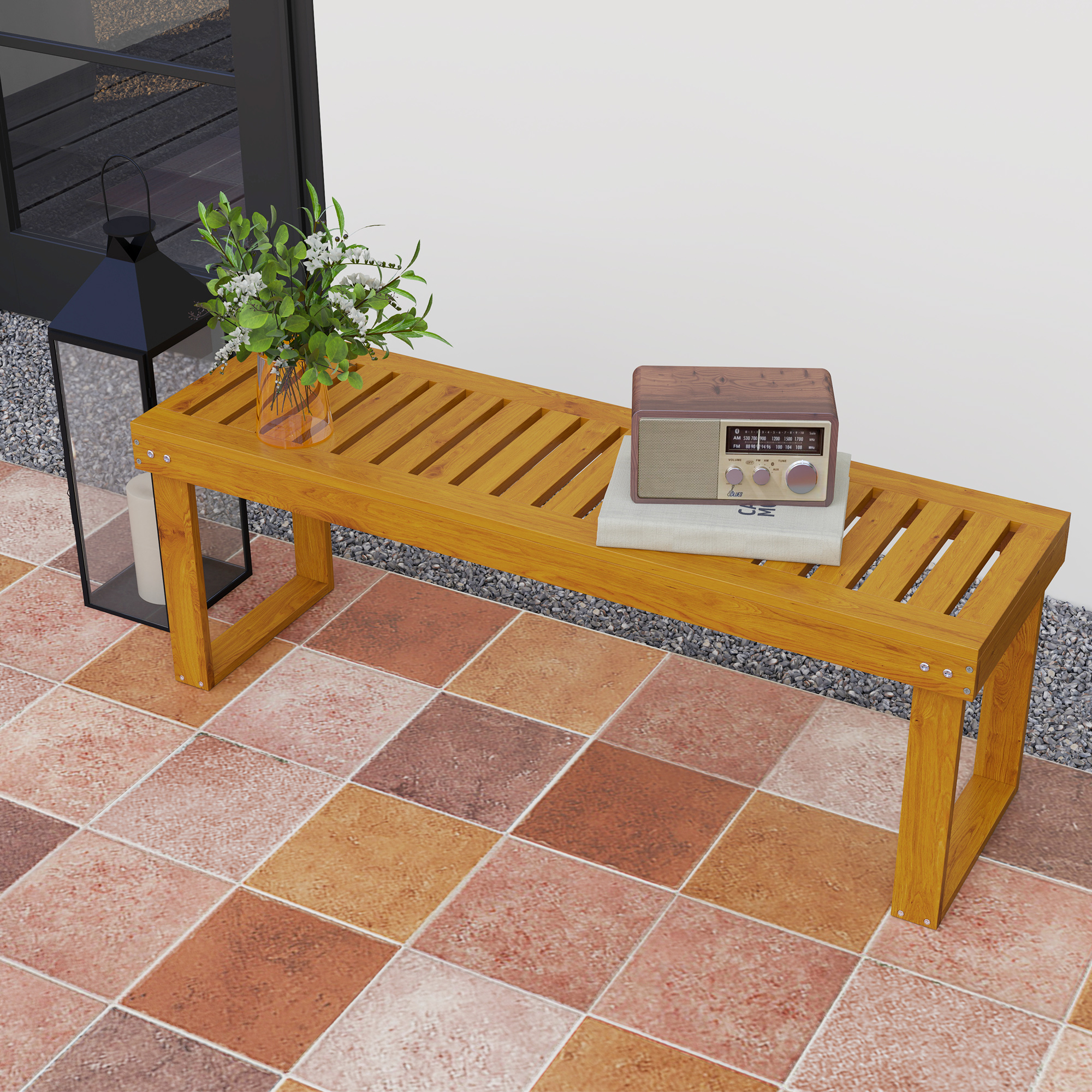 Banco de madera con radio, libro, linterna y flores en suelo de baldosas.