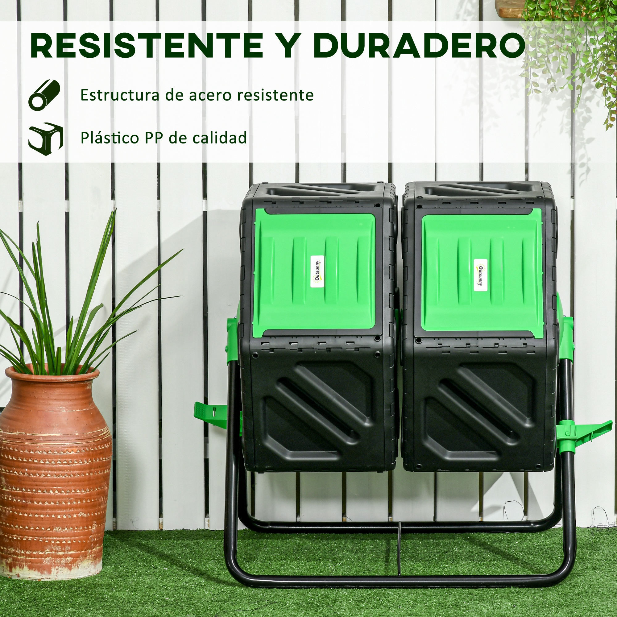Dos compostadores negros con tapas verdes sobre césped artificial frente a valla blanca.