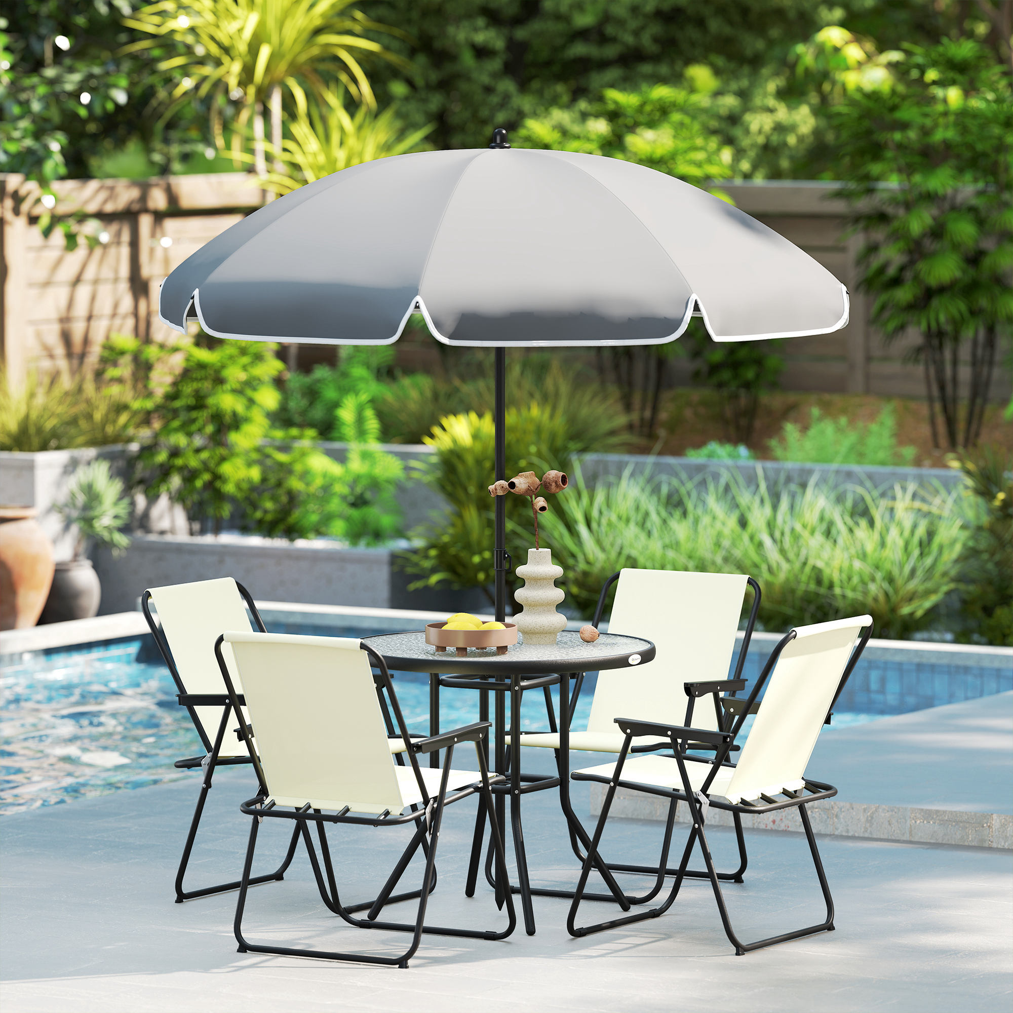 Una mesa redonda con cuatro sillas bajo un paraguas al aire libre junto a una piscina.