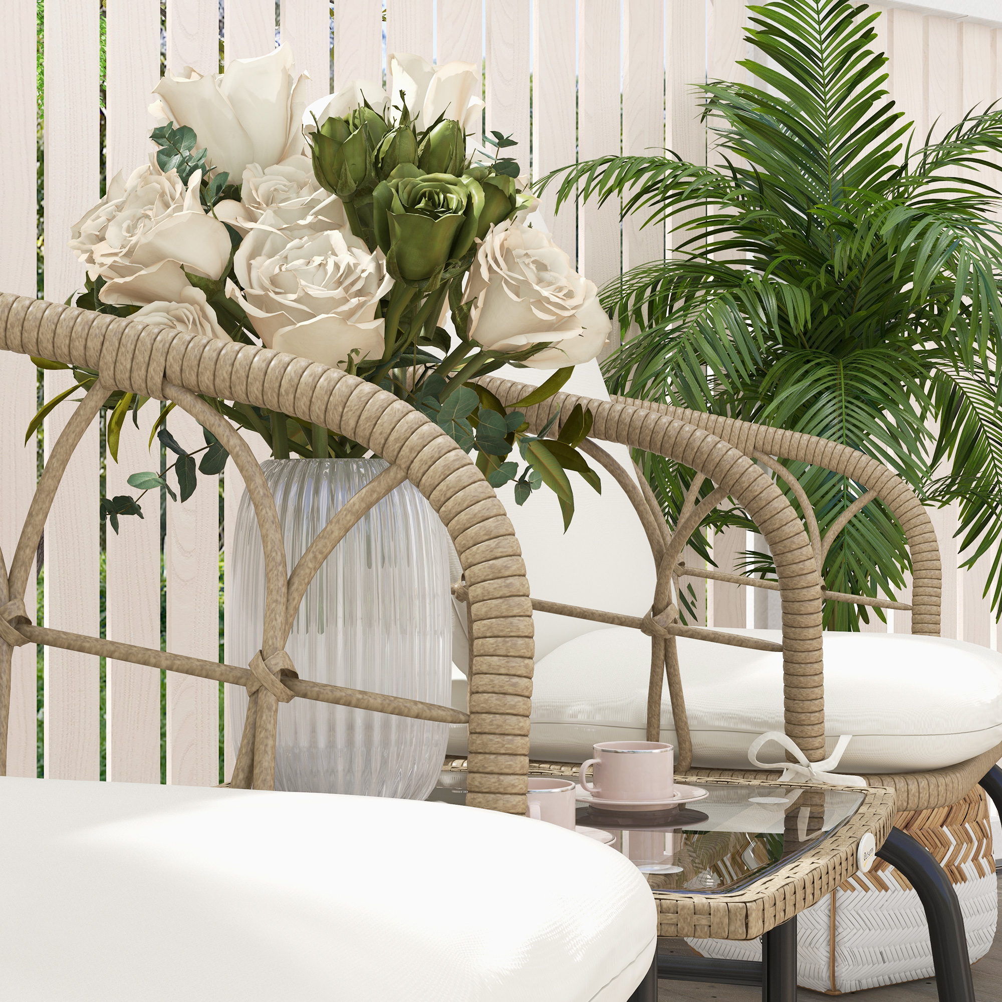 Dos sillones de ratán con cojines blancos y una mesa con flores y tazas.