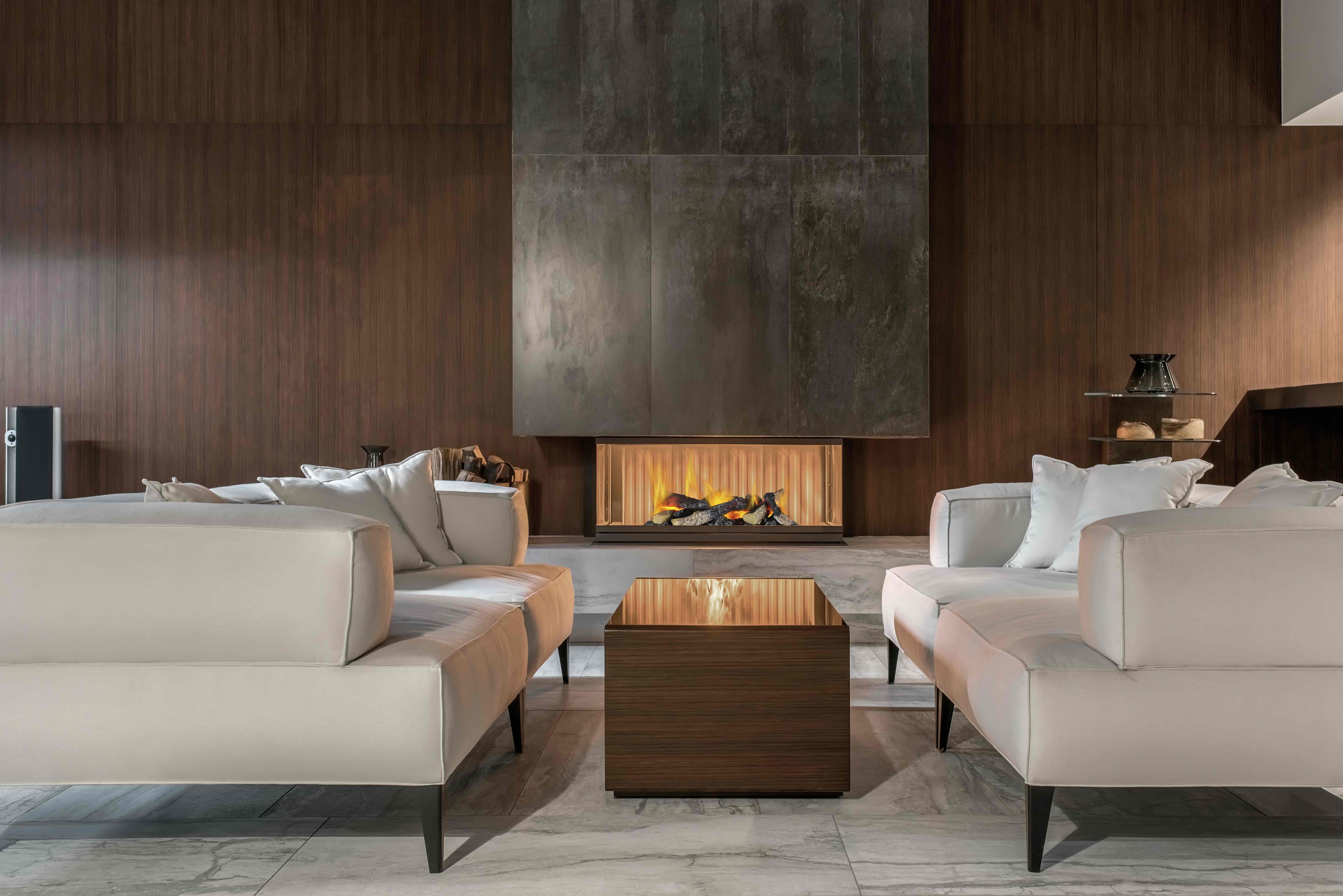 Ein modernes Wohnzimmer mit weißen Sofas, einem Holztisch und einem Kamin.