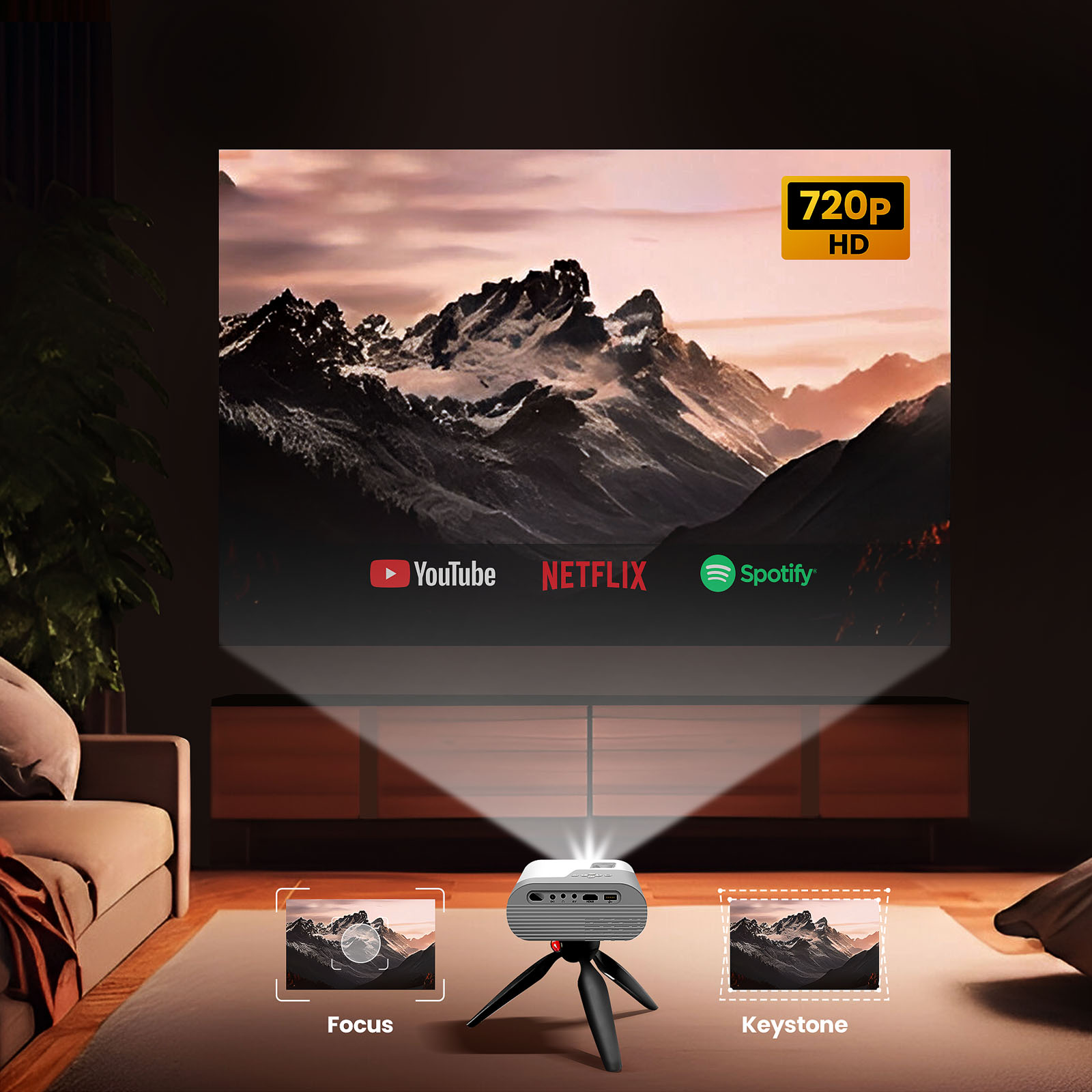 Ein kleiner Projektor auf einem Stativ projiziert ein Bergpanorama mit YouTube, Netflix, Spotify.