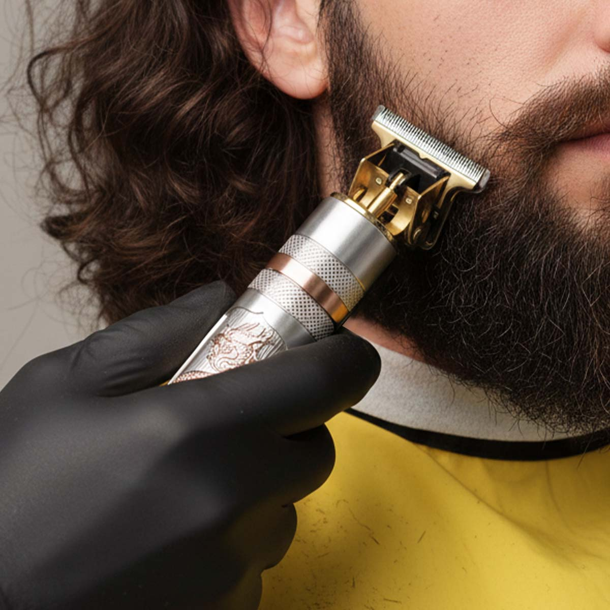Une personne en gants noirs taille une barbe avec un rasoir électrique argenté.
