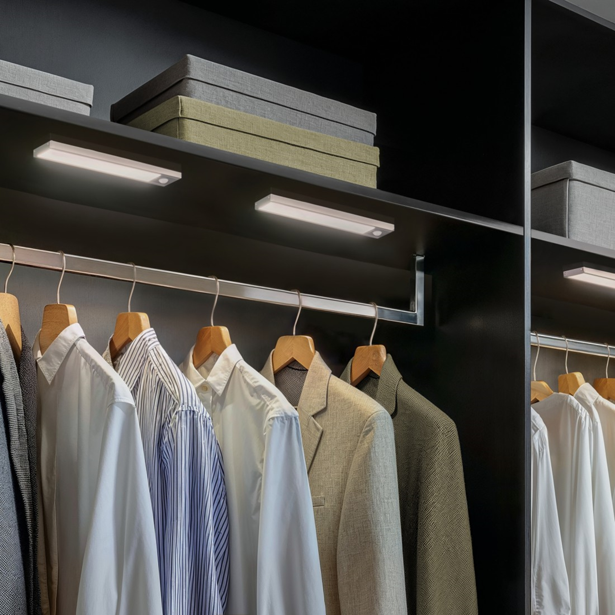 Kleidung auf Bügeln in einem dunklen Schrank mit Beleuchtung und Boxen.