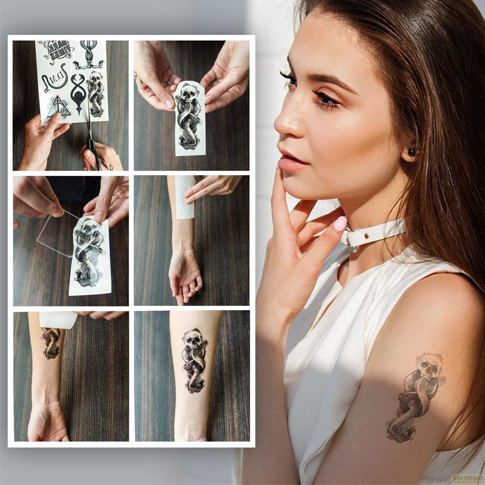 Schlange und Totenkopf-Aufklebetattoo wird auf den Arm aufgetragen.