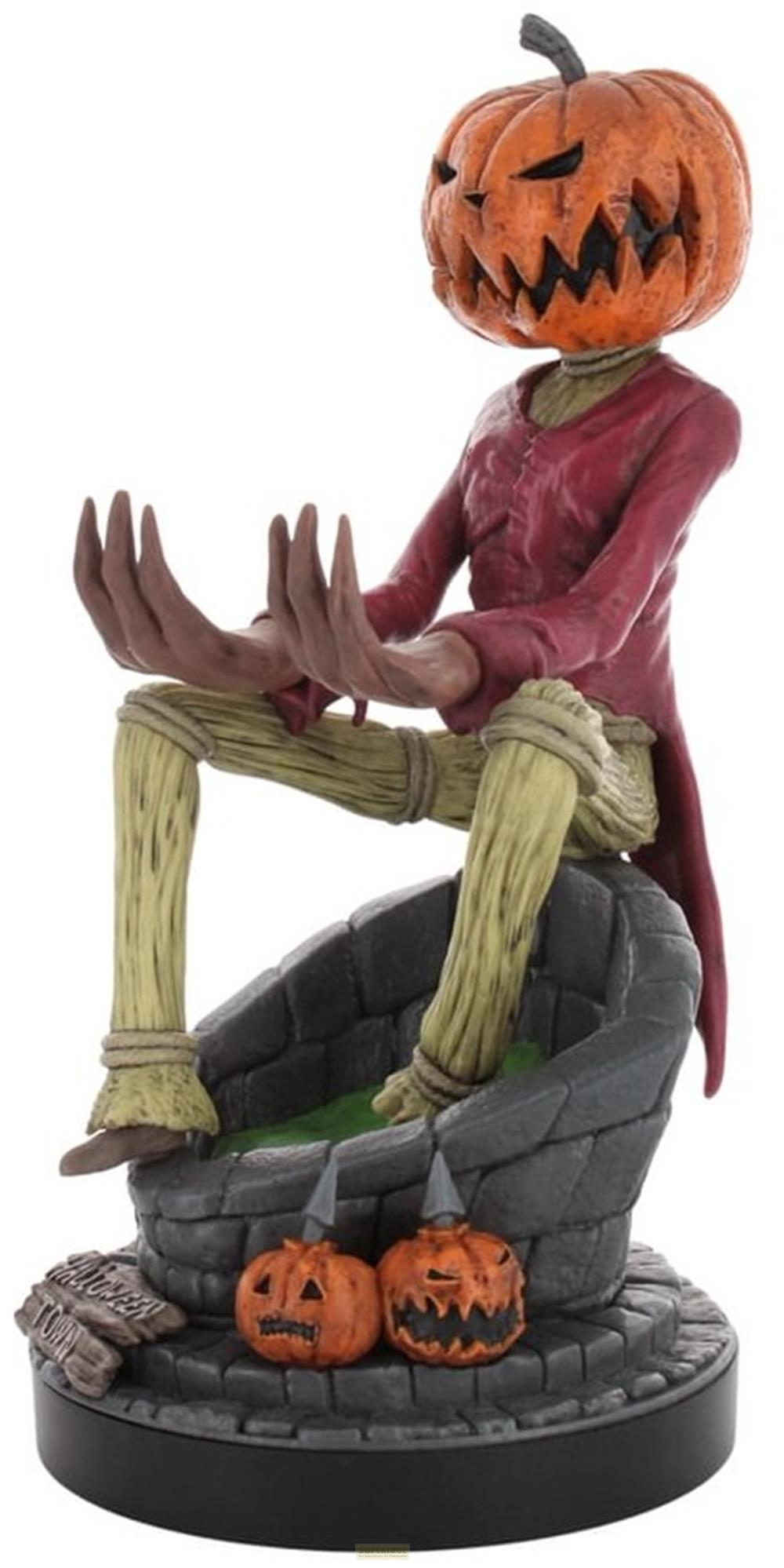 Figura aterradora con cabeza de calabaza sentada en un pozo con dos calabazas.