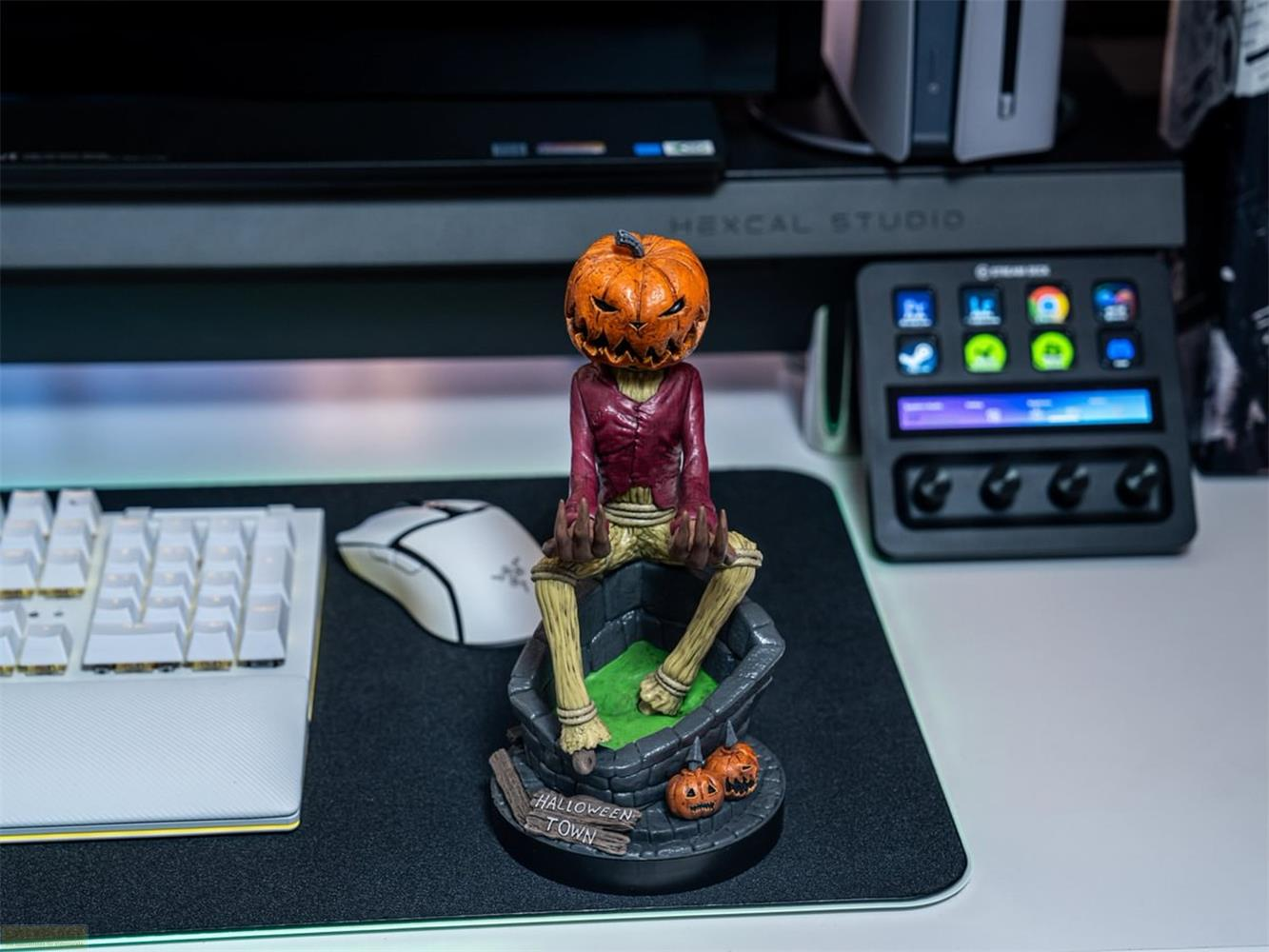 Figura de Halloween con cabeza de calabaza sentada en un pozo con calabazas.