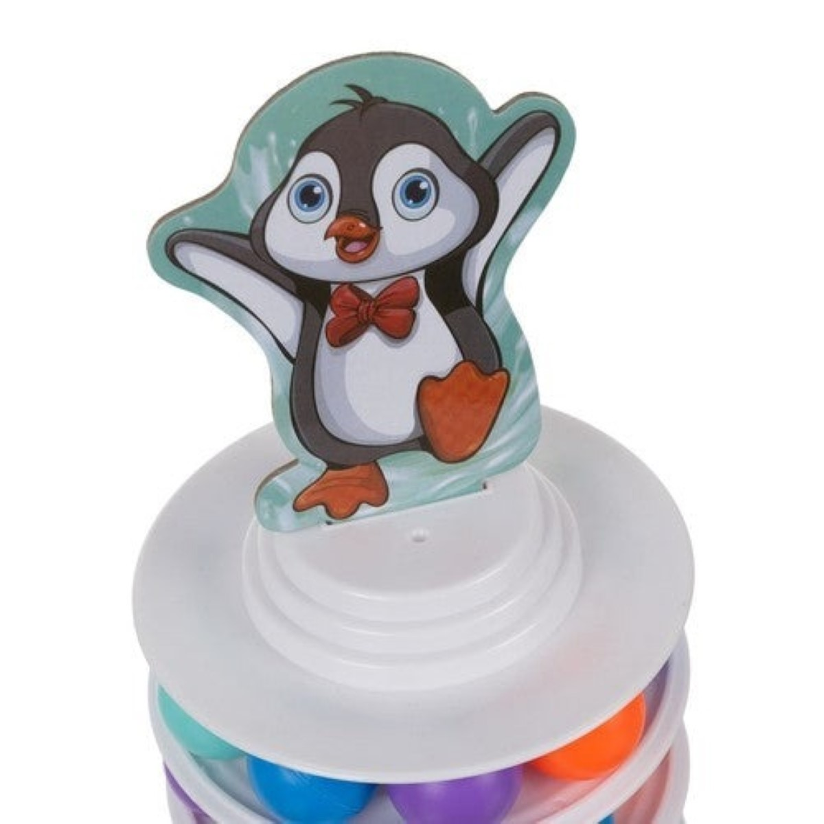 Un pingüino de dibujos animados con pajarita roja está en una torre de juguete blanca con pelotas.