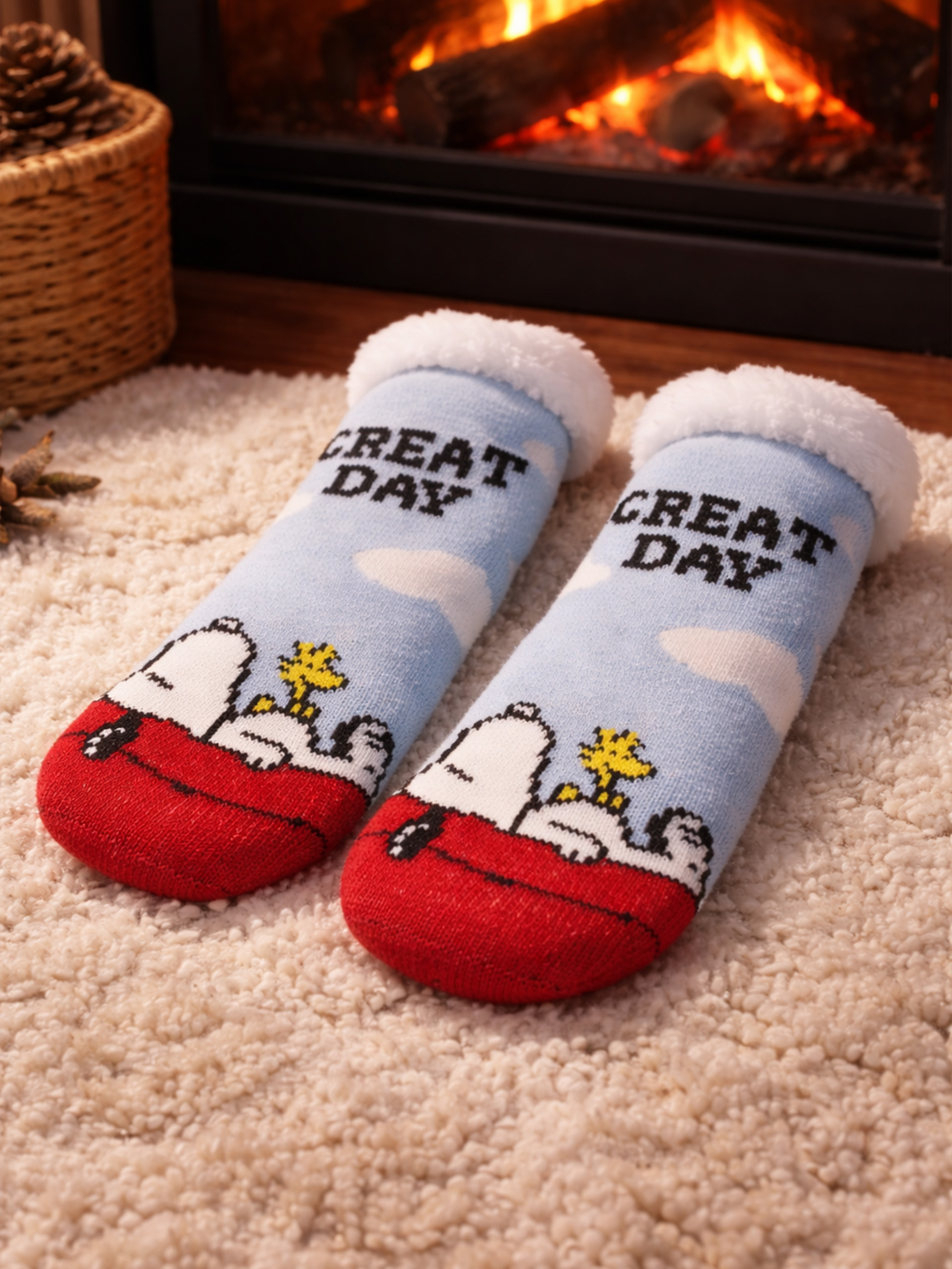 Socken mit Snoopy und Woodstock vor einem Kaminfeuer.