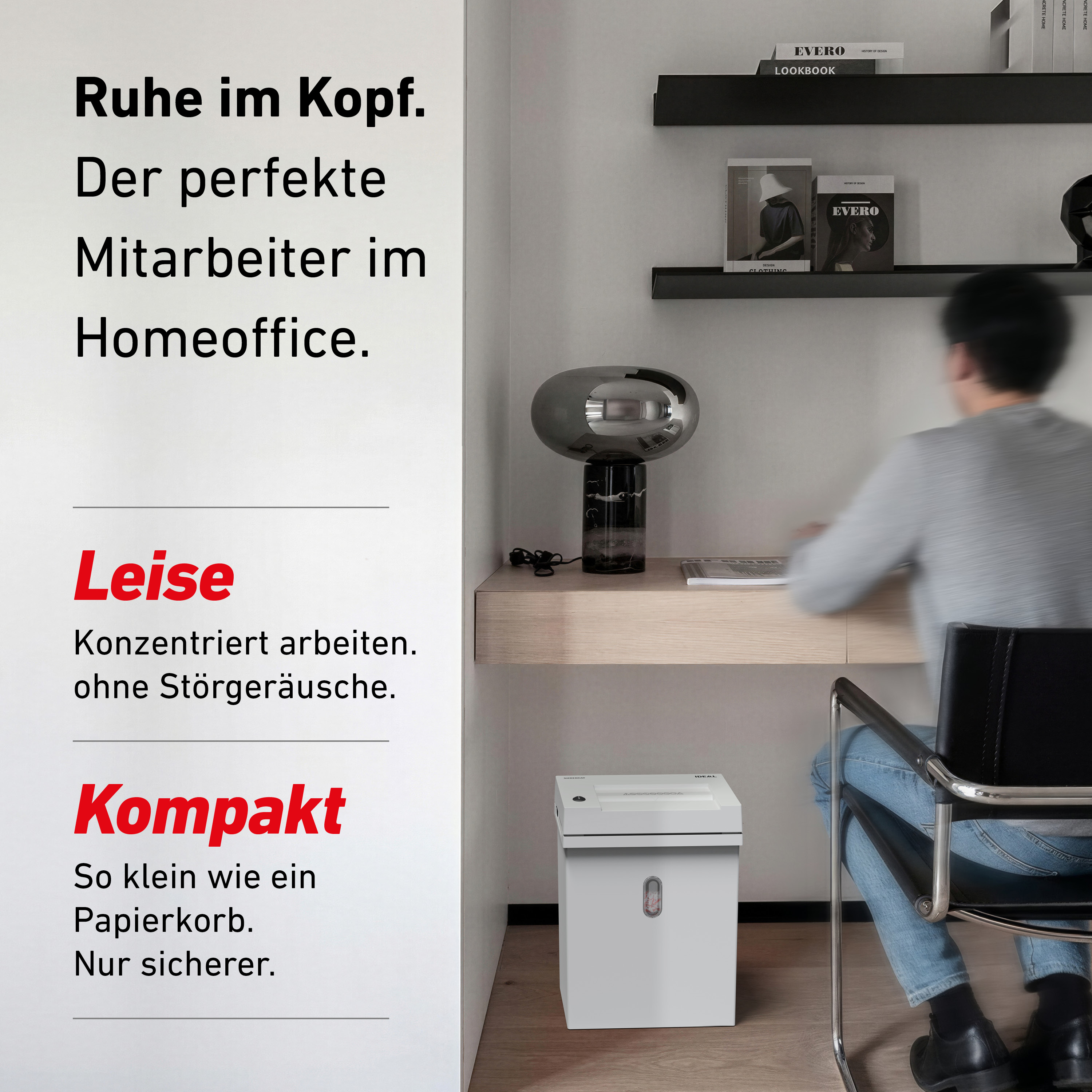 Ein Mann arbeitet am Schreibtisch, daneben steht ein Aktenvernichter.