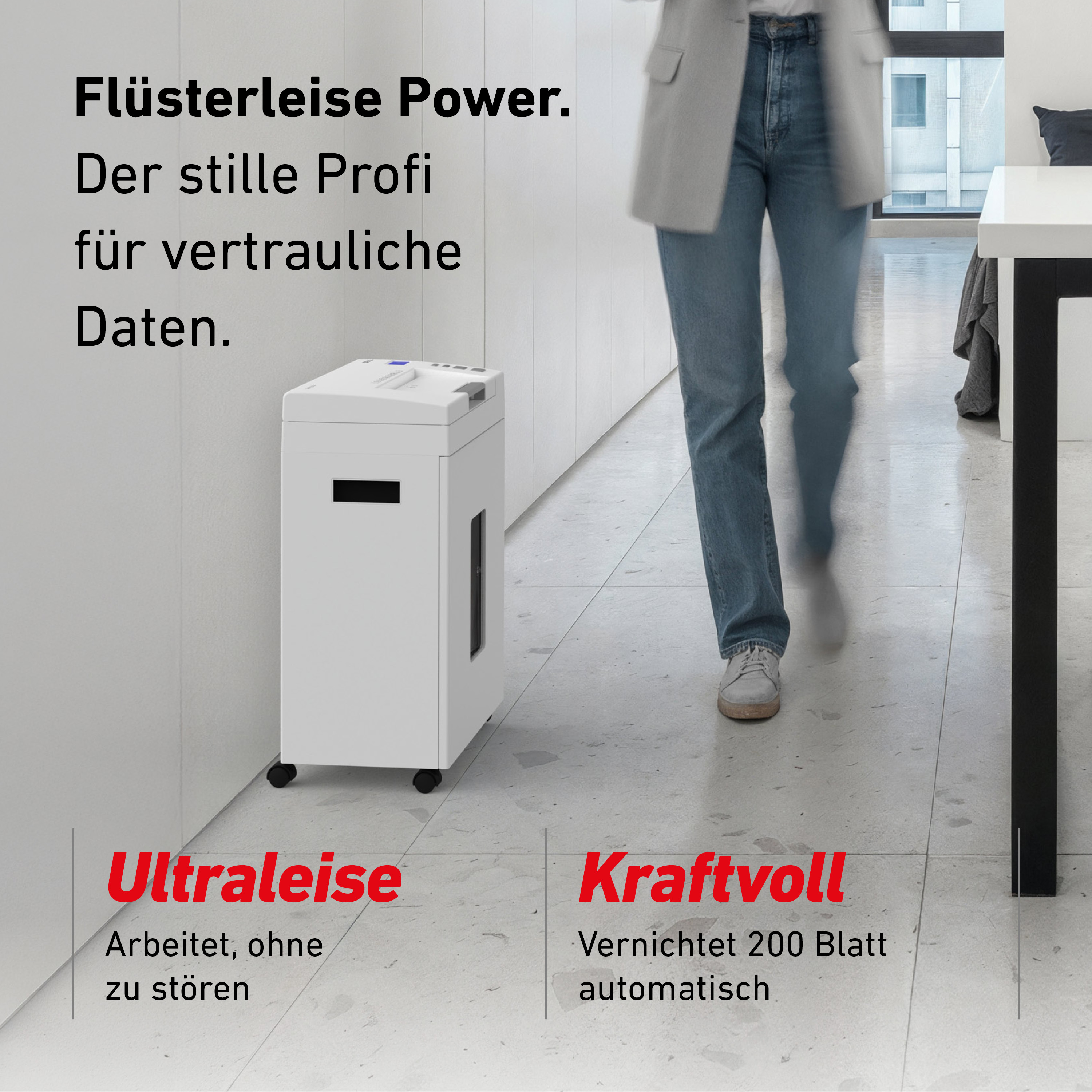 Ein weißer Aktenvernichter steht in einem Flur. Eine Person geht vorbei.