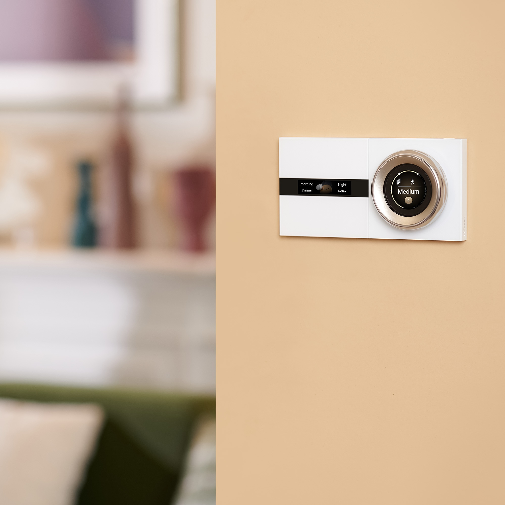 Biały termostat z okrągłym wyświetlaczem pokazującym "Średni".