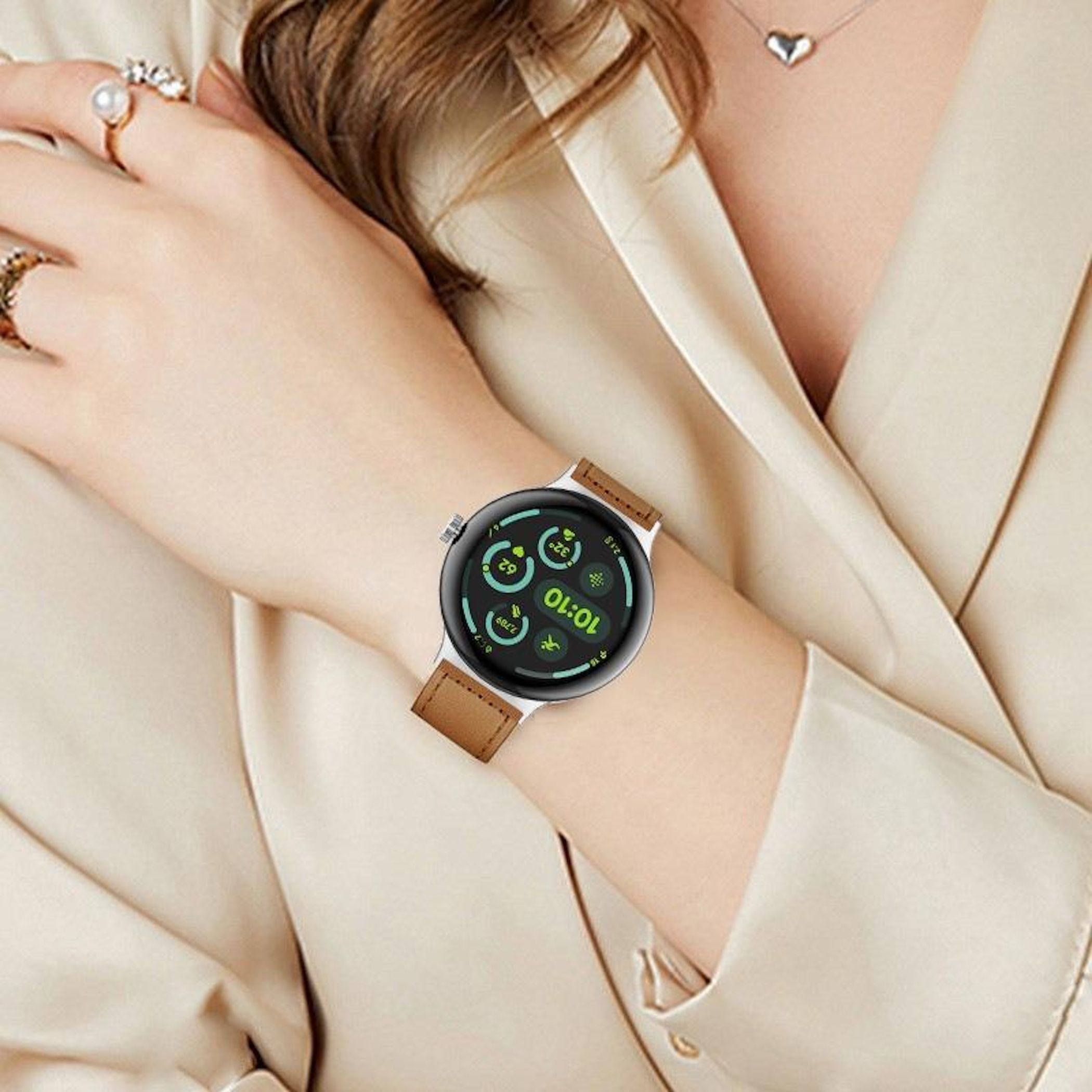 Eine Frau trägt eine Smartwatch mit braunem Armband und einem hellbeigen Hemd.