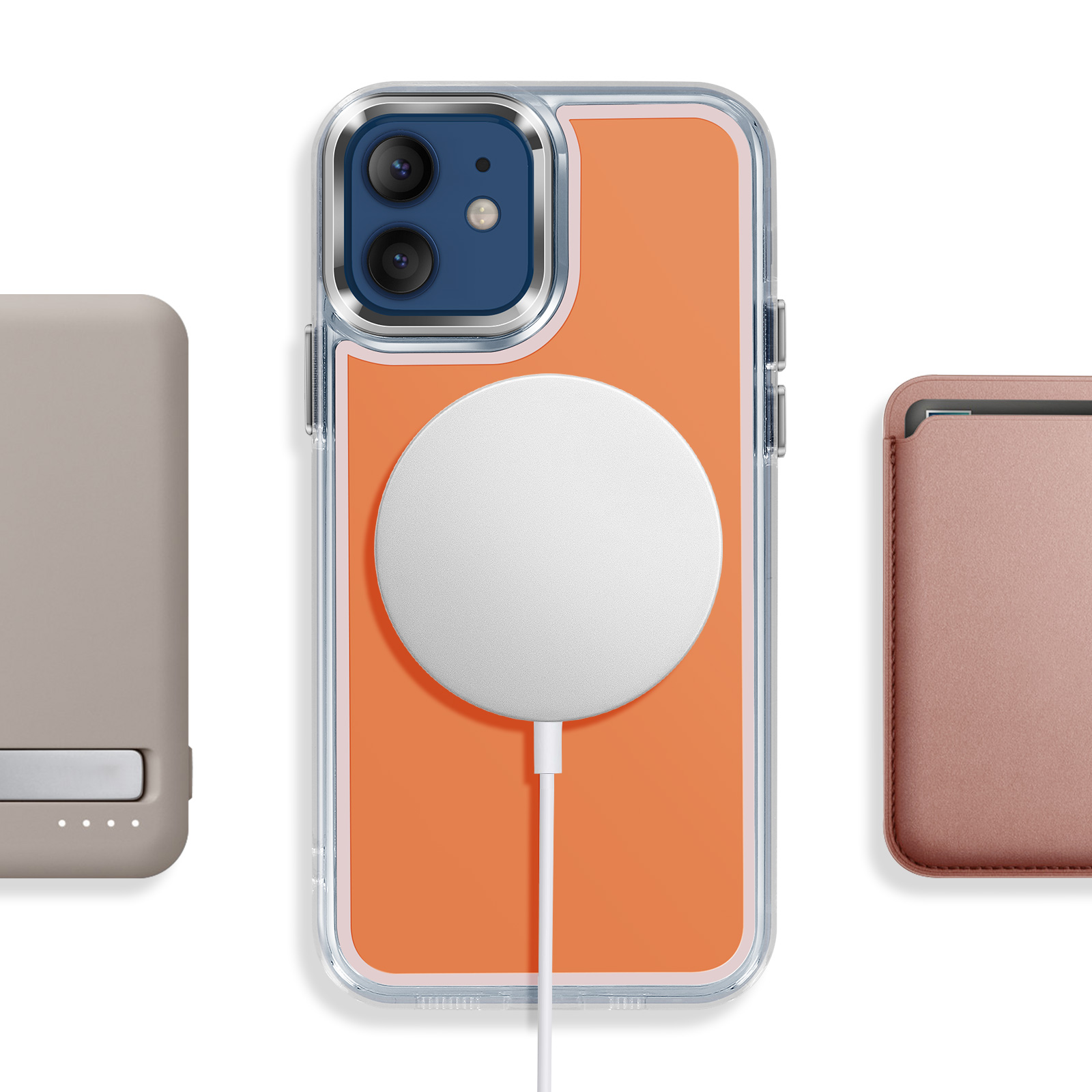 Un iPhone orange avec chargeur MagSafe, à côté d'une batterie grise et d'un étui rose.