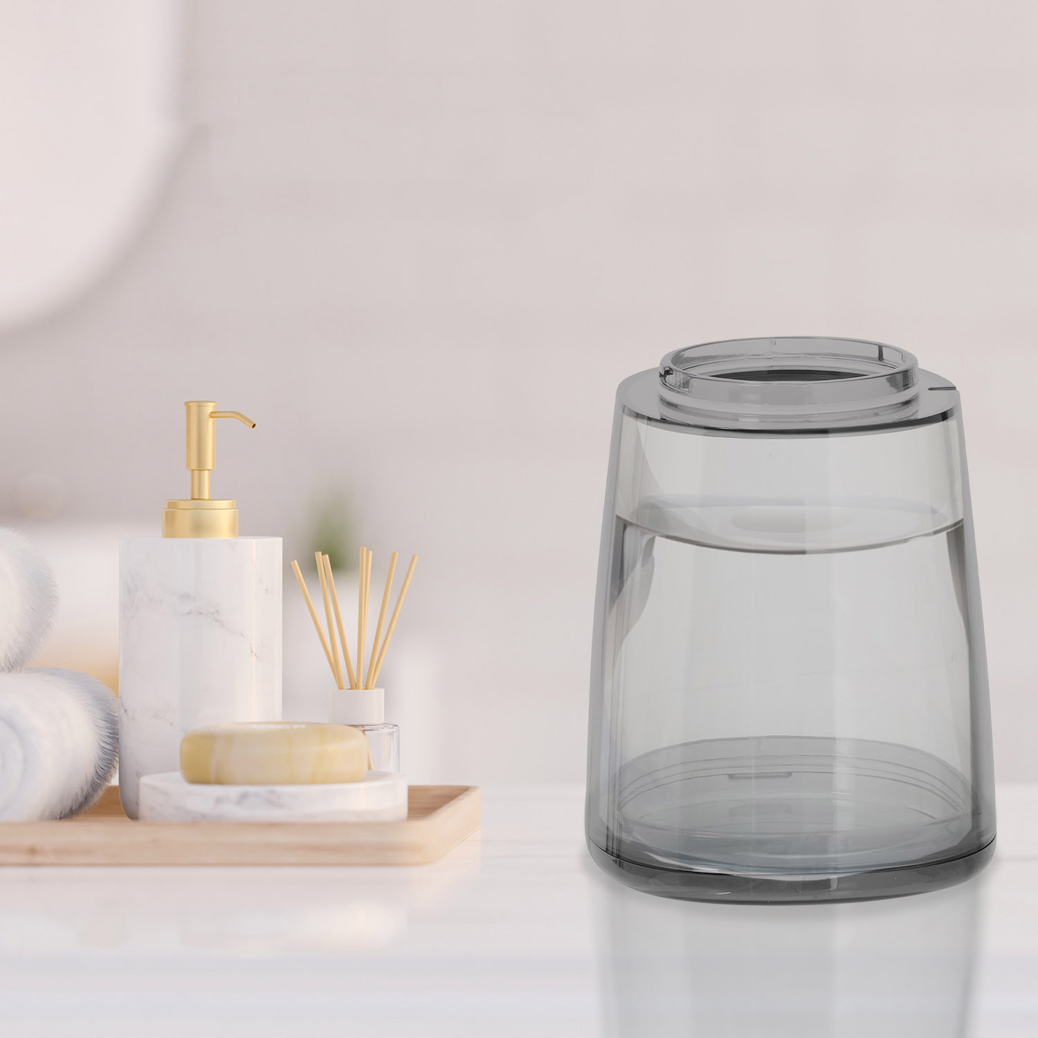 Zeepdispenser, zeep, rietjesdiffusor en een glas water op een dienblad.