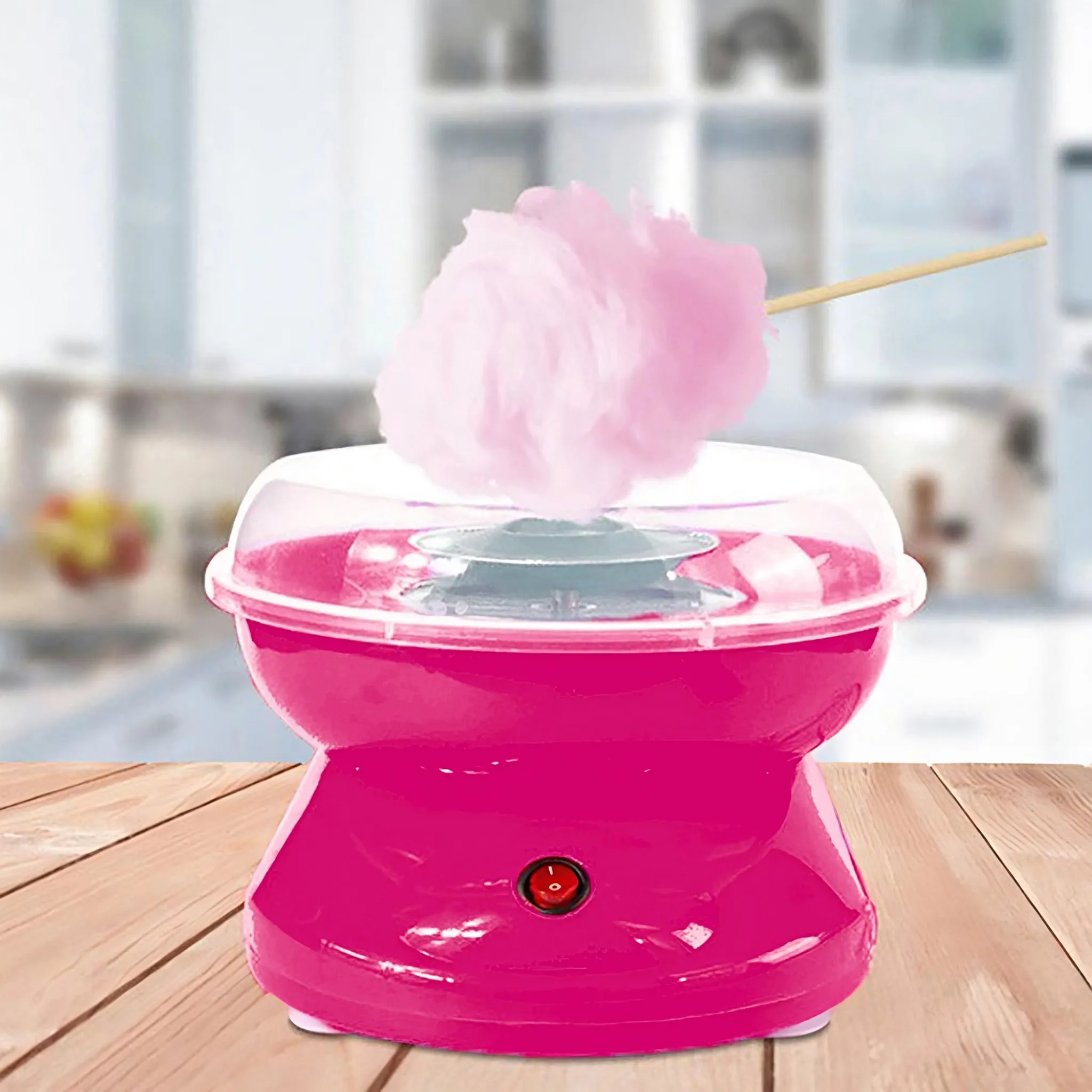 Eine rosa Zuckerwattemaschine mit einem Holzstab, auf dem Zuckerwatte aufgewickelt ist.