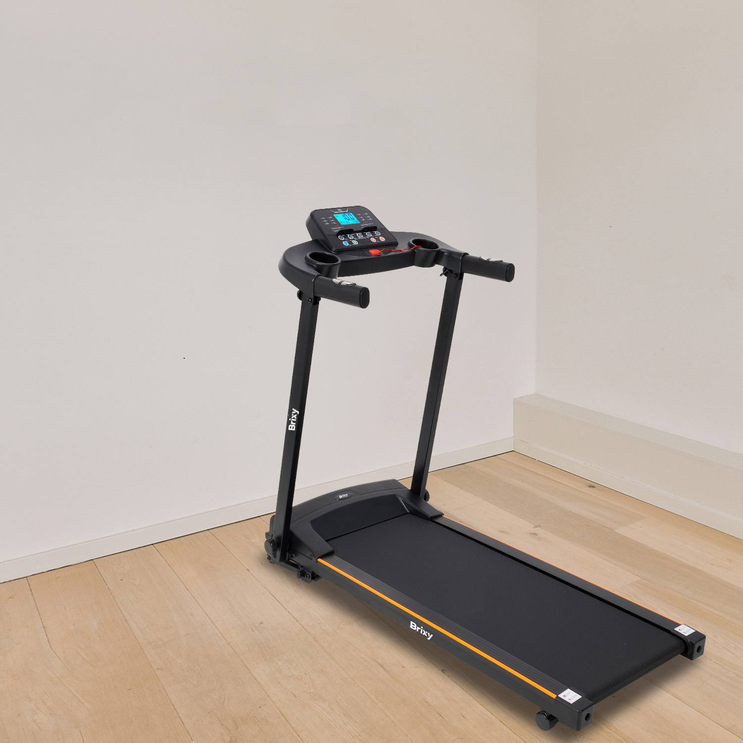 A black treadmill with orange accents stands on a wooden floor.