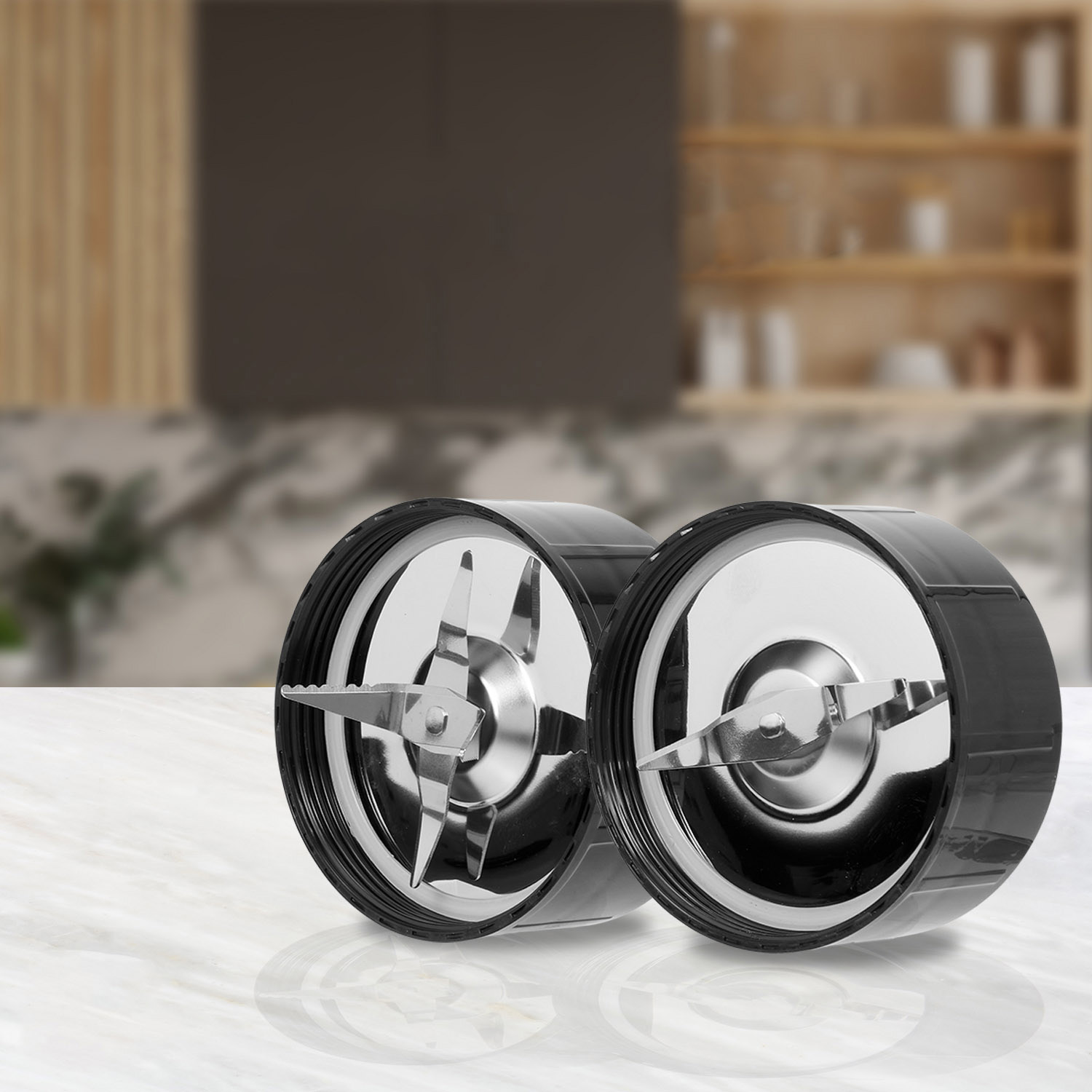 Two black blender cups with polished blades on a marble table.