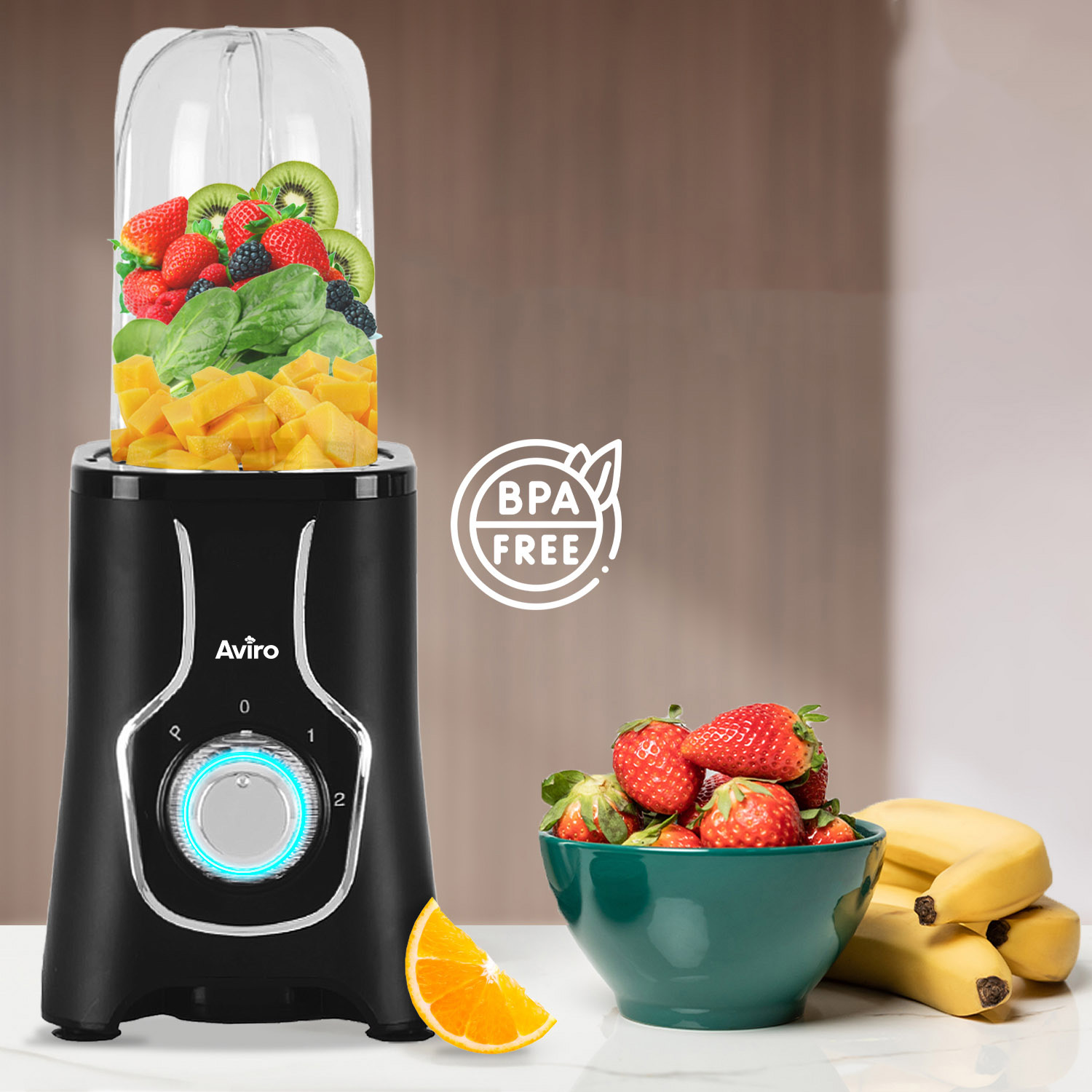 Black blender filled with fruit, berries, spinach, orange and banana pieces.