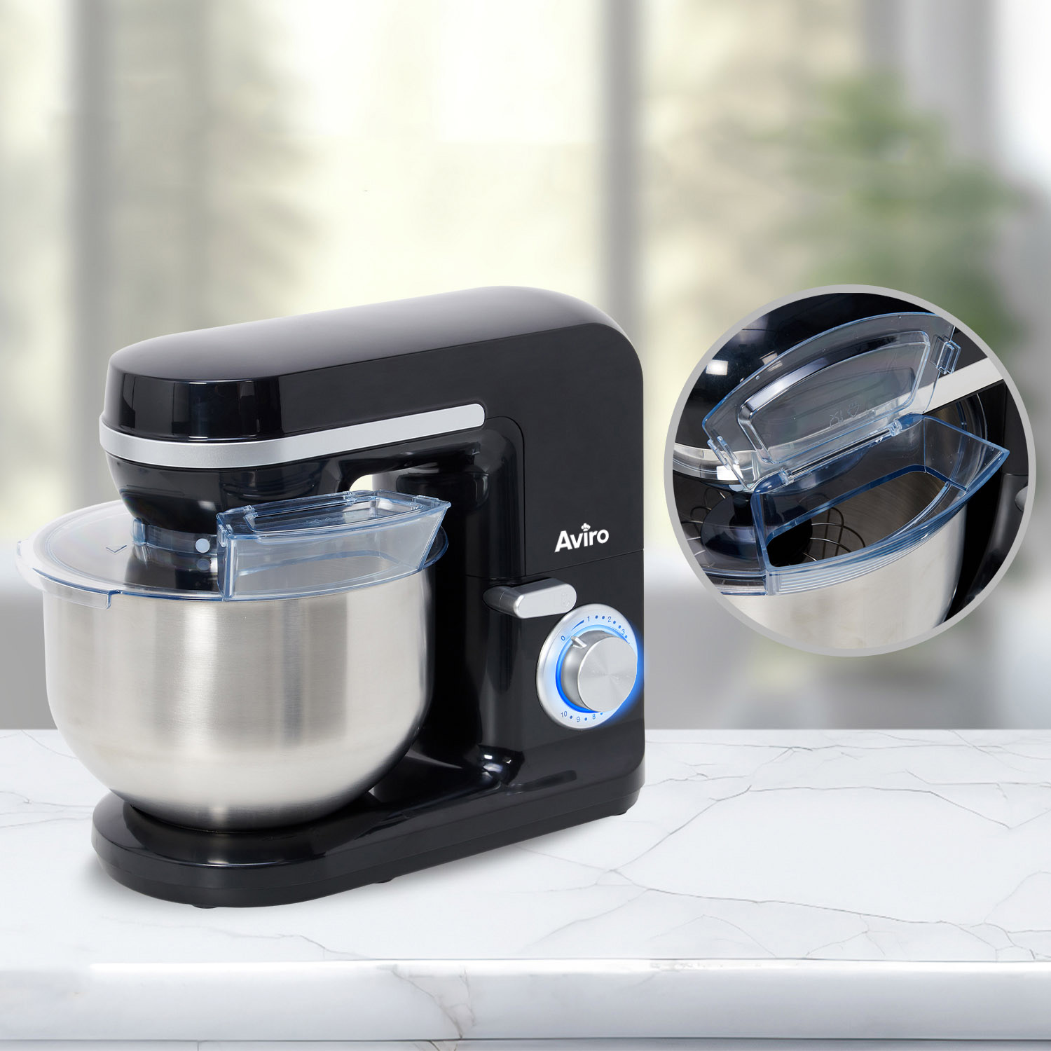Black kitchen mixer with stainless steel bowl on marble table. Detail view above.