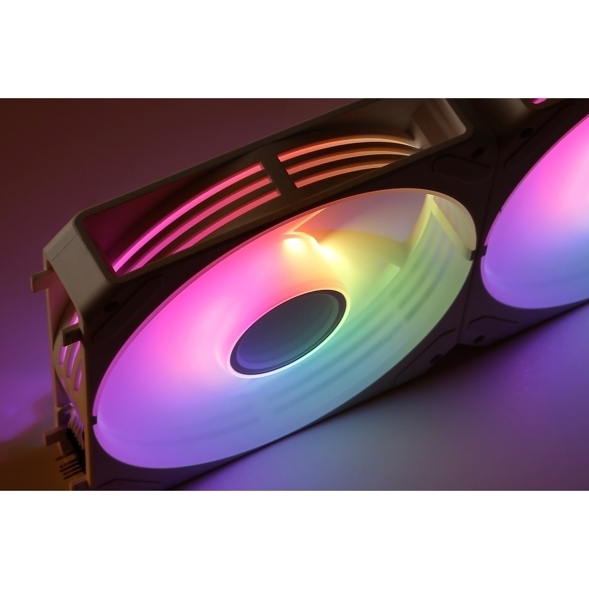 Un ventilador de computadora con iluminación RGB en tonos morados, rosas, amarillos y verdes.