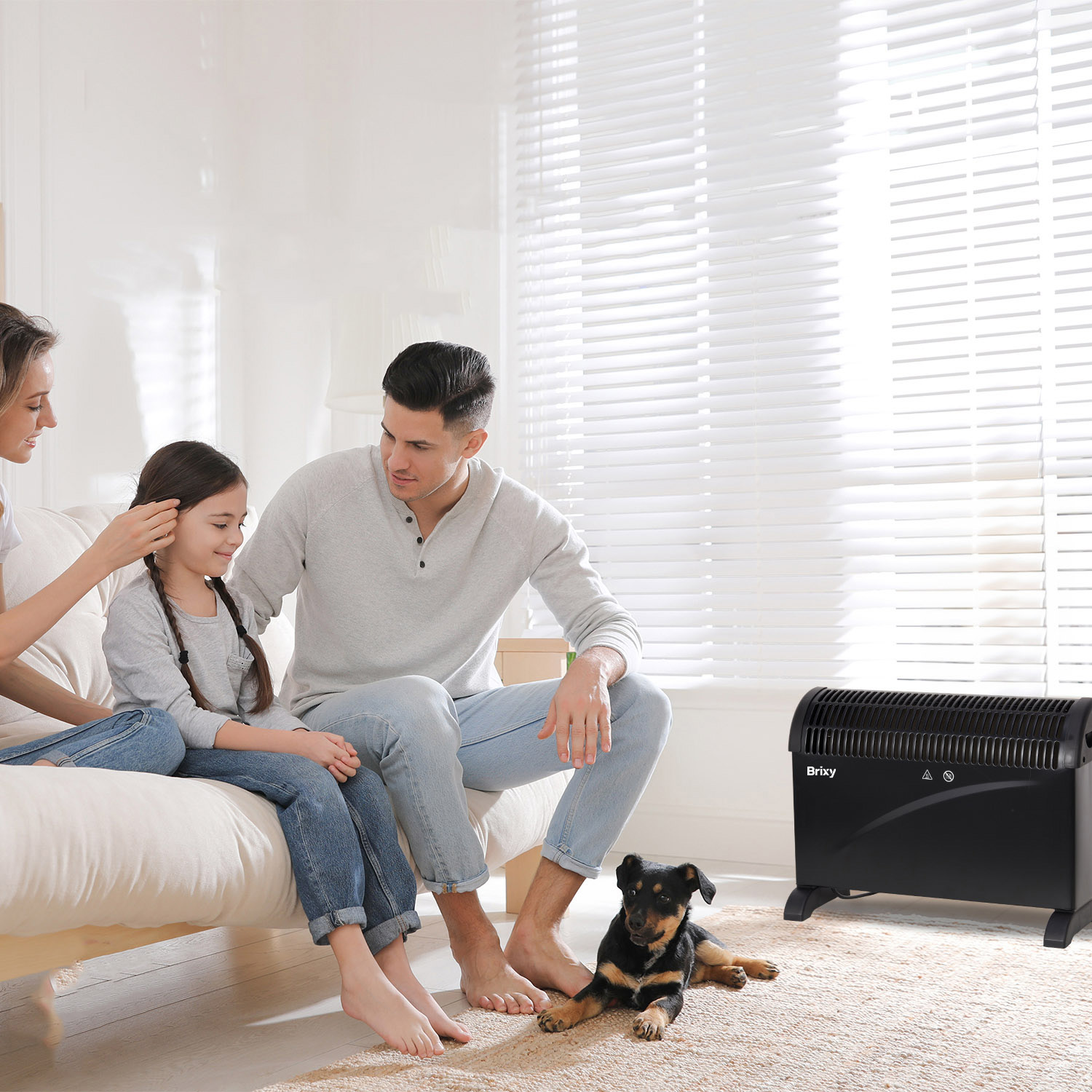 Family sits on sofa, dog lies by heater in front of blinds.
